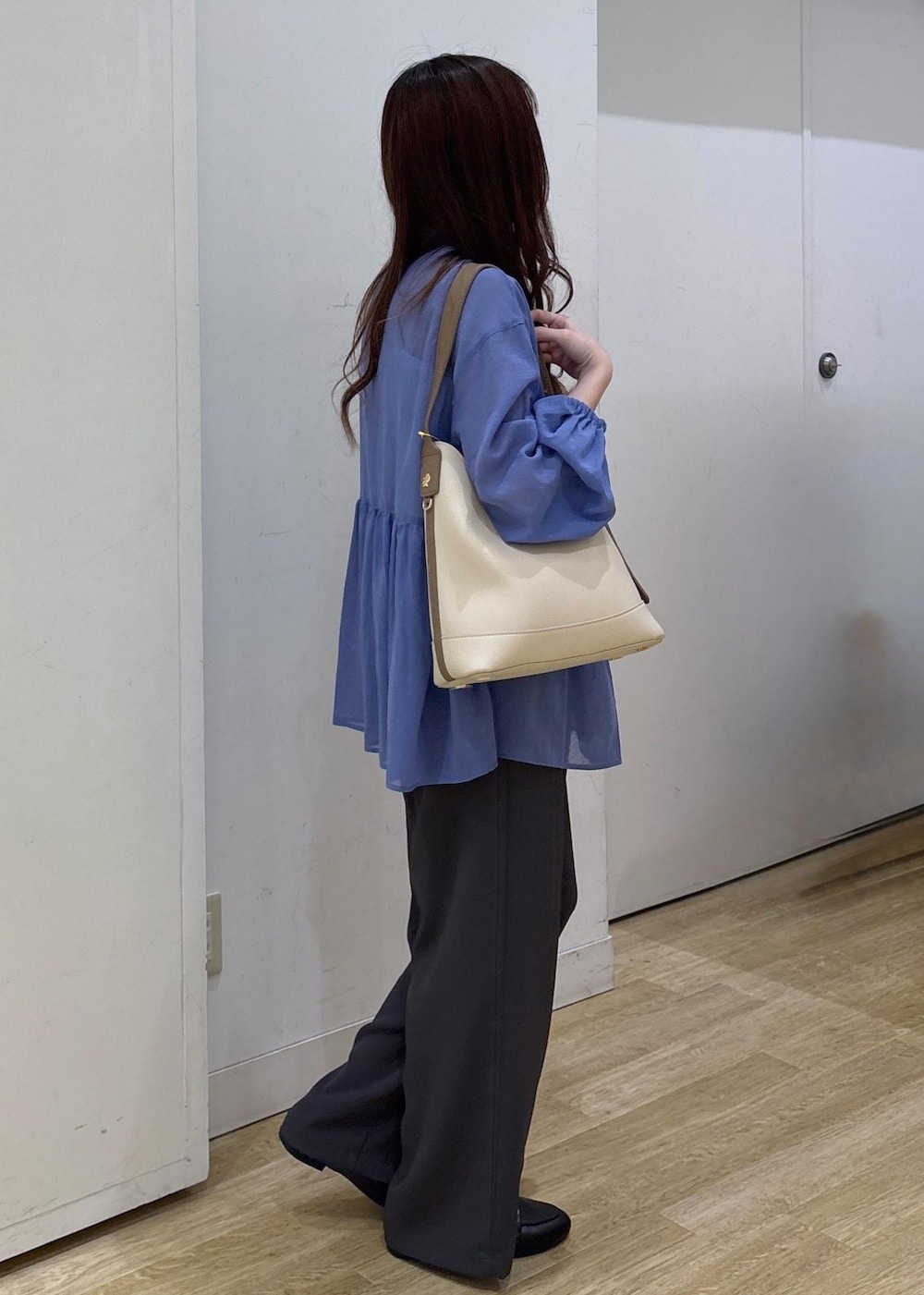 ホワイト系のショルダーバッグ、ブラック系のローファー、グレー系のその他パンツを着用したレディースの春コーディネートの2枚目の写真