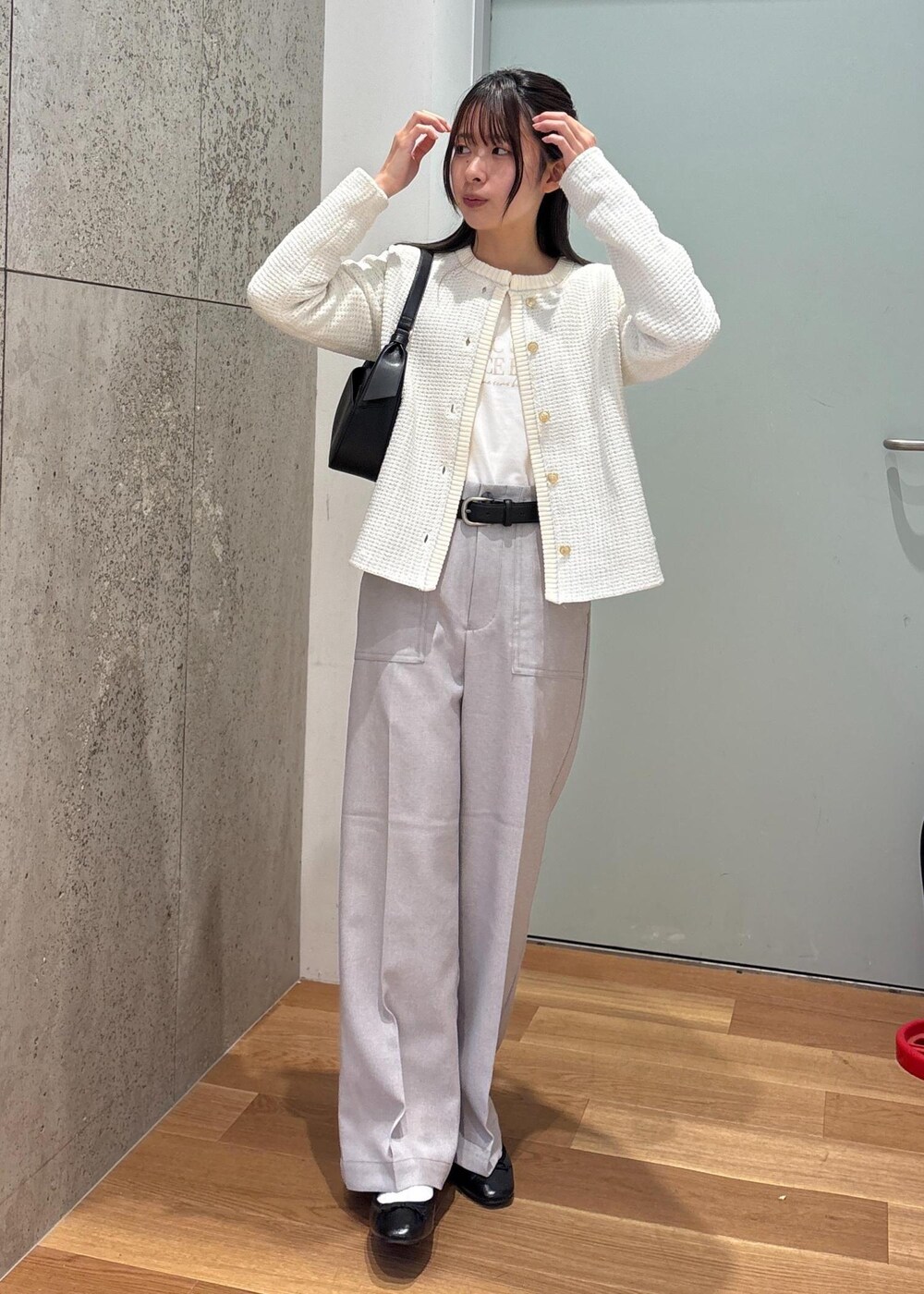ブラック系のハンドバッグ、グレー系のその他パンツ、ホワイト系のカーディガン/ボレロを着用したレディースの春コーディネートの2枚目の写真