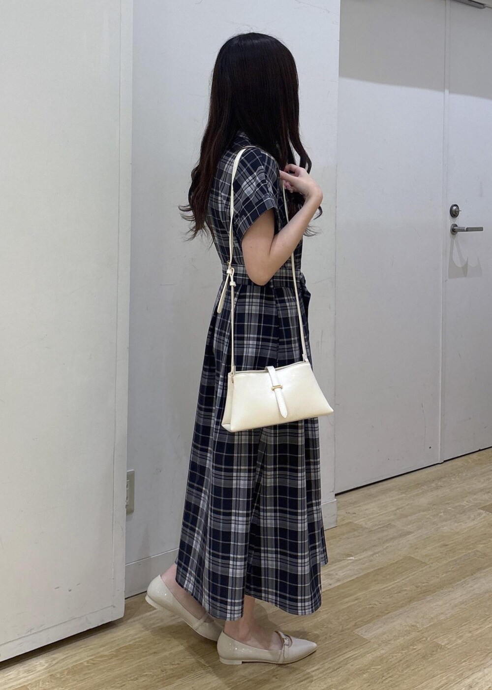 ホワイト系のパンプス、ホワイト系のショルダーバッグ、ブルー系のワンピースを着用したレディースの春コーディネートの2枚目の写真
