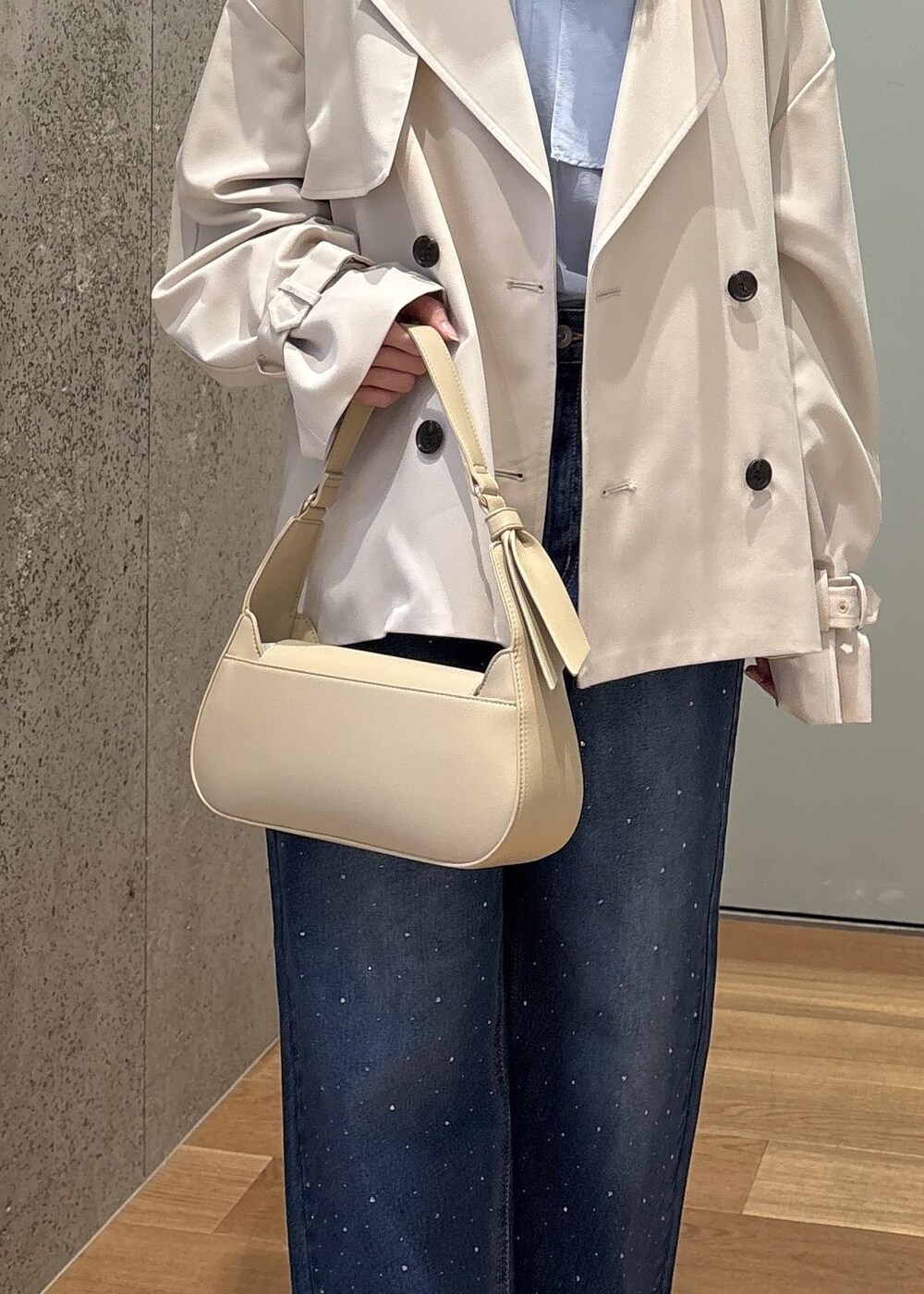 ベージュ系のハンドバッグ、ブルー系のデニムパンツ、ブルー系のシャツ/ブラウスを着用したレディースの春コーディネートの9枚目の写真
