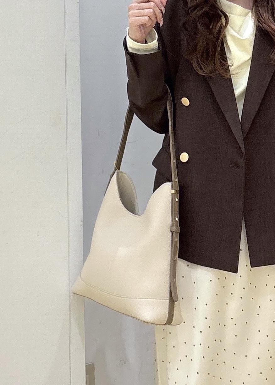 ホワイト系のショルダーバッグ、ベージュ系のTシャツ/カットソー、ブラウン系のテーラードジャケットを着用したレディースの春コーディネートの7枚目の写真