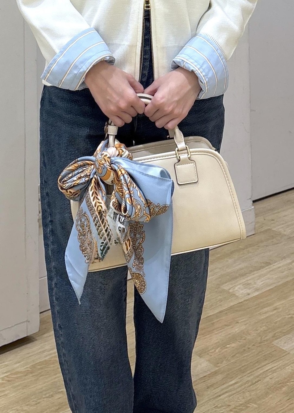 ホワイト系のボストンバッグ、ホワイト系のカーディガン/ボレロ、ブルー系のシャツ/ブラウスを着用したレディースの春コーディネートの7枚目の写真