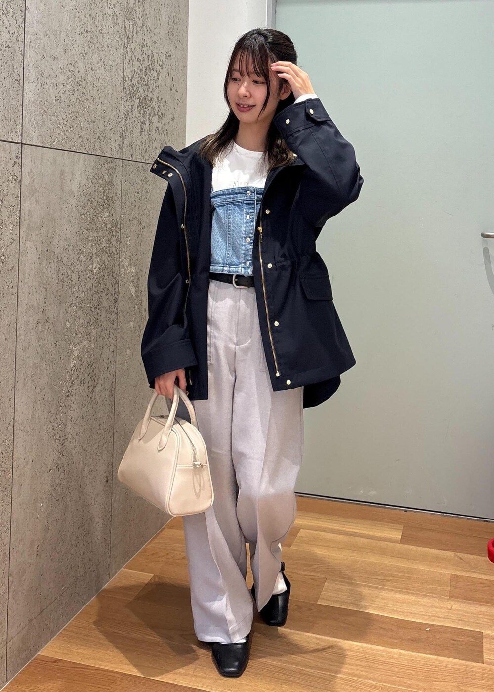 ブルー系のベスト、ブルー系のマウンテンパーカー、ホワイト系のTシャツ/カットソーを着用したレディースの春コーディネートの2枚目の写真