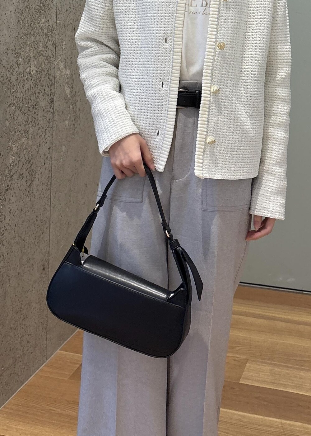 ブラック系のハンドバッグ、グレー系のその他パンツ、ホワイト系のカーディガン/ボレロを着用したレディースの春コーディネートの7枚目の写真