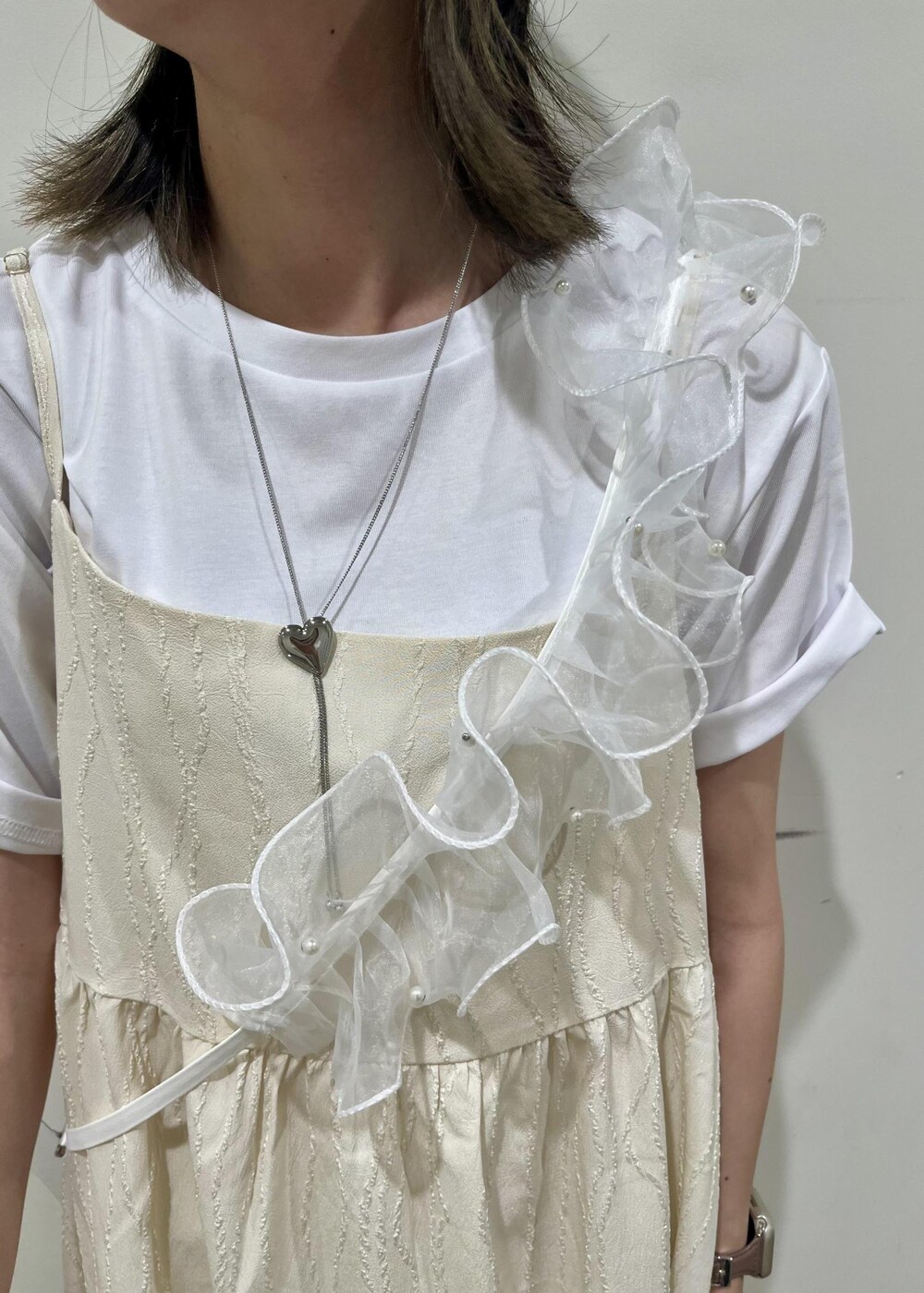 シルバー系のトートバッグ、ホワイト系のワンピース、ホワイト系のTシャツ/カットソーを着用したレディースの夏コーディネートの3枚目の写真
