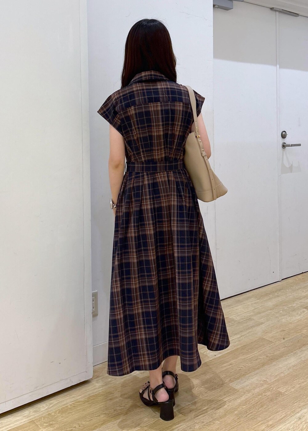 ベージュ系のショルダーバッグ、ブルー系のワンピースを着用したレディースの夏コーディネートの4枚目の写真