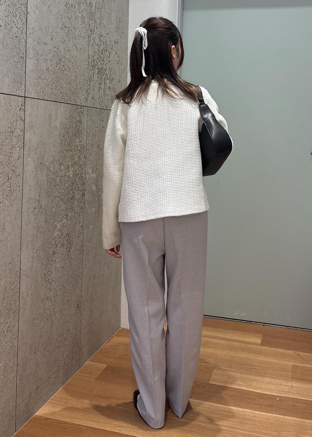 ブラック系のハンドバッグ、グレー系のその他パンツ、ホワイト系のカーディガン/ボレロを着用したレディースの春コーディネートの4枚目の写真