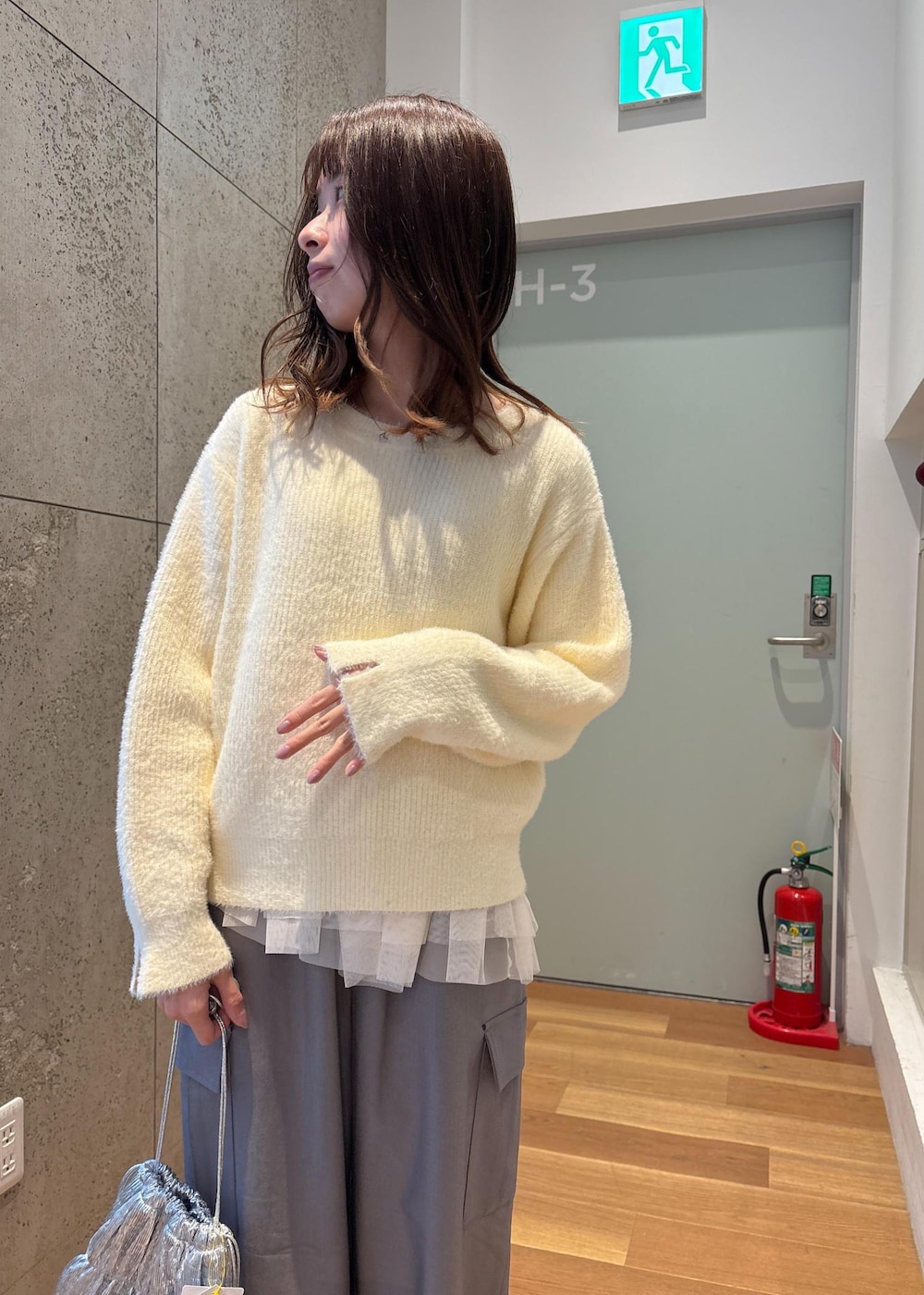 ホワイト系のベスト、シルバー系のショルダーバッグ、ホワイト系のニット/セーターを着用したレディースの春コーディネートの5枚目の写真