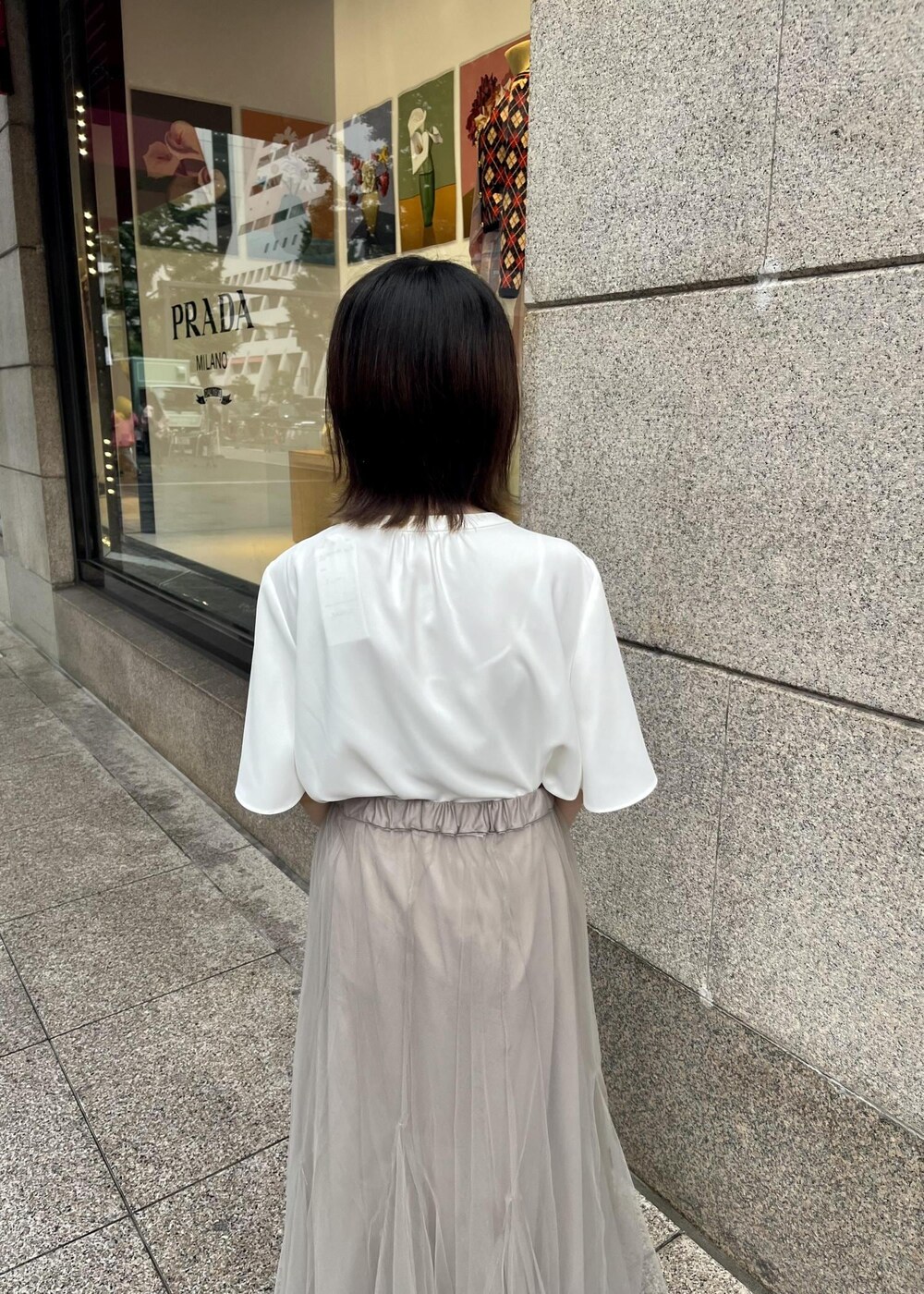 ベージュ系のスカート、ホワイト系のシャツ/ブラウス、ホワイト系のサンダルを着用したレディースの夏コーディネートの4枚目の写真