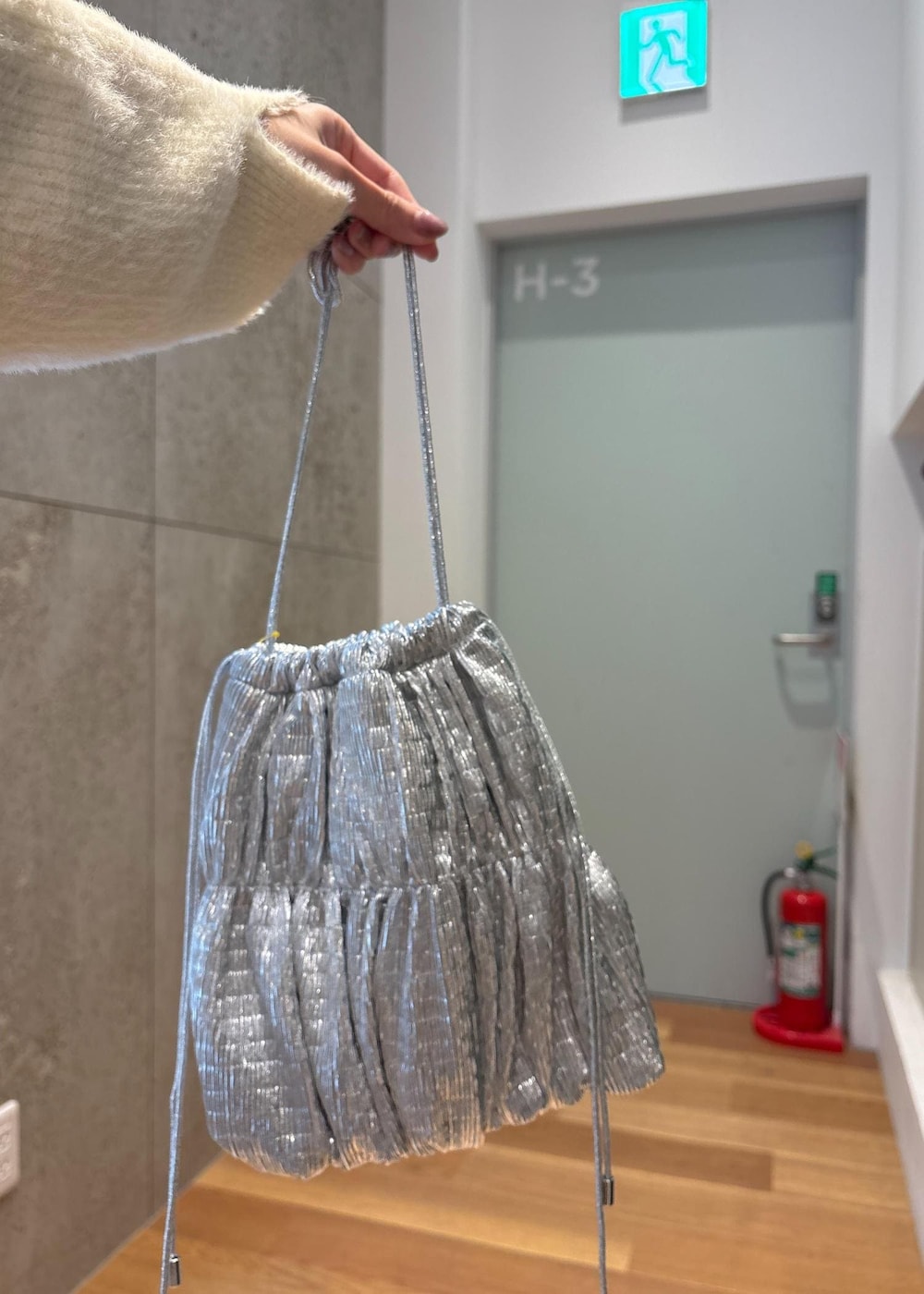 ホワイト系のベスト、シルバー系のショルダーバッグ、ホワイト系のニット/セーターを着用したレディースの春コーディネートの7枚目の写真