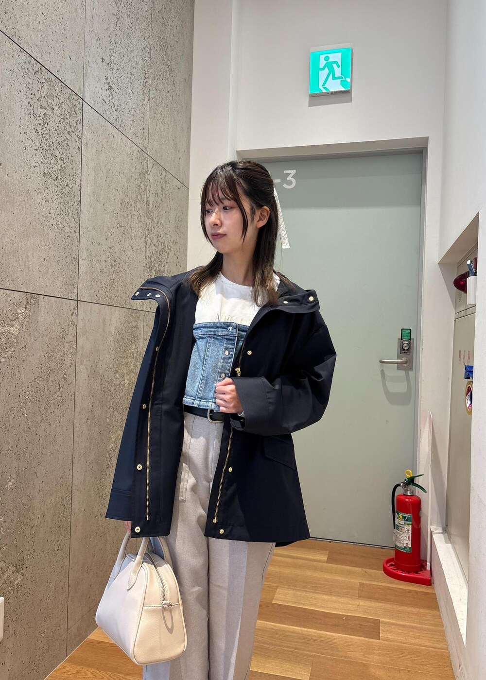 ブルー系のベスト、ブルー系のマウンテンパーカー、ホワイト系のTシャツ/カットソーを着用したレディースの春コーディネートの6枚目の写真