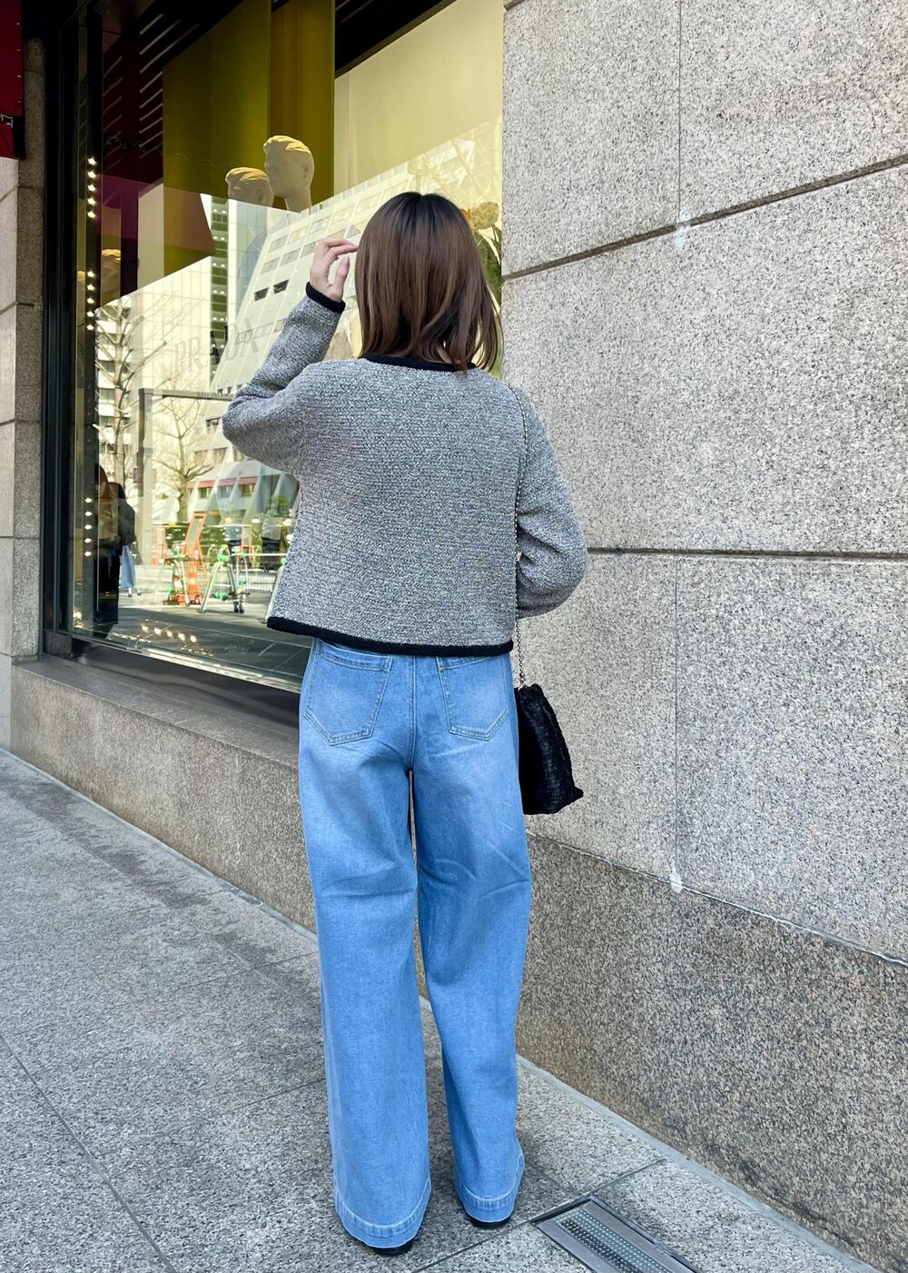 ブラック系のローファー、ブラック系のショルダーバッグ、ブルー系のデニムパンツを着用したレディースの春コーディネートの2枚目の写真