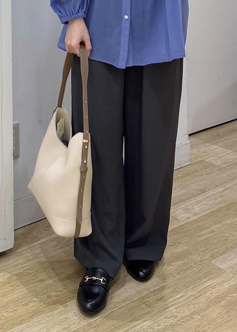 ホワイト系のショルダーバッグ、ブラック系のローファー、グレー系のその他パンツを着用したレディースの春コーディネートの6枚目の写真