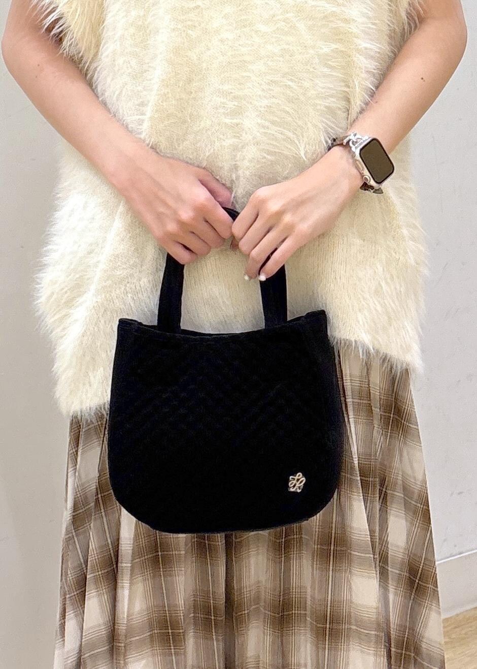 ホワイト系のタンクトップ、ホワイト系のベスト、イエロー系のスカートを着用したレディースの秋コーディネートの7枚目の写真