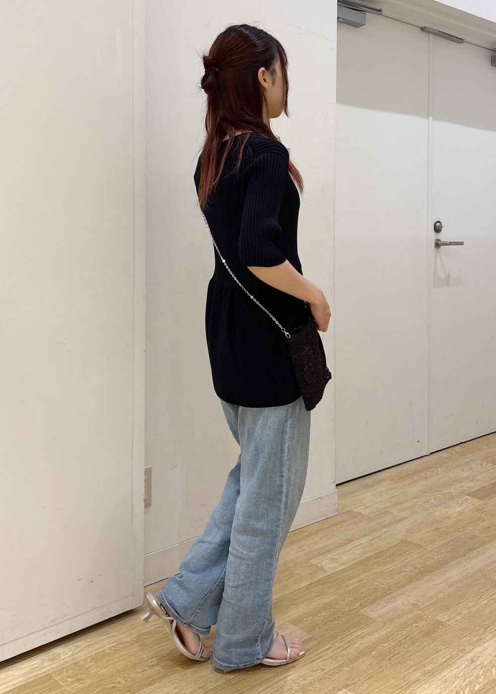 ブルー系のデニムパンツ、ブラック系のショルダーバッグ、シルバー系のサンダルを着用したレディースの夏コーディネートの4枚目の写真