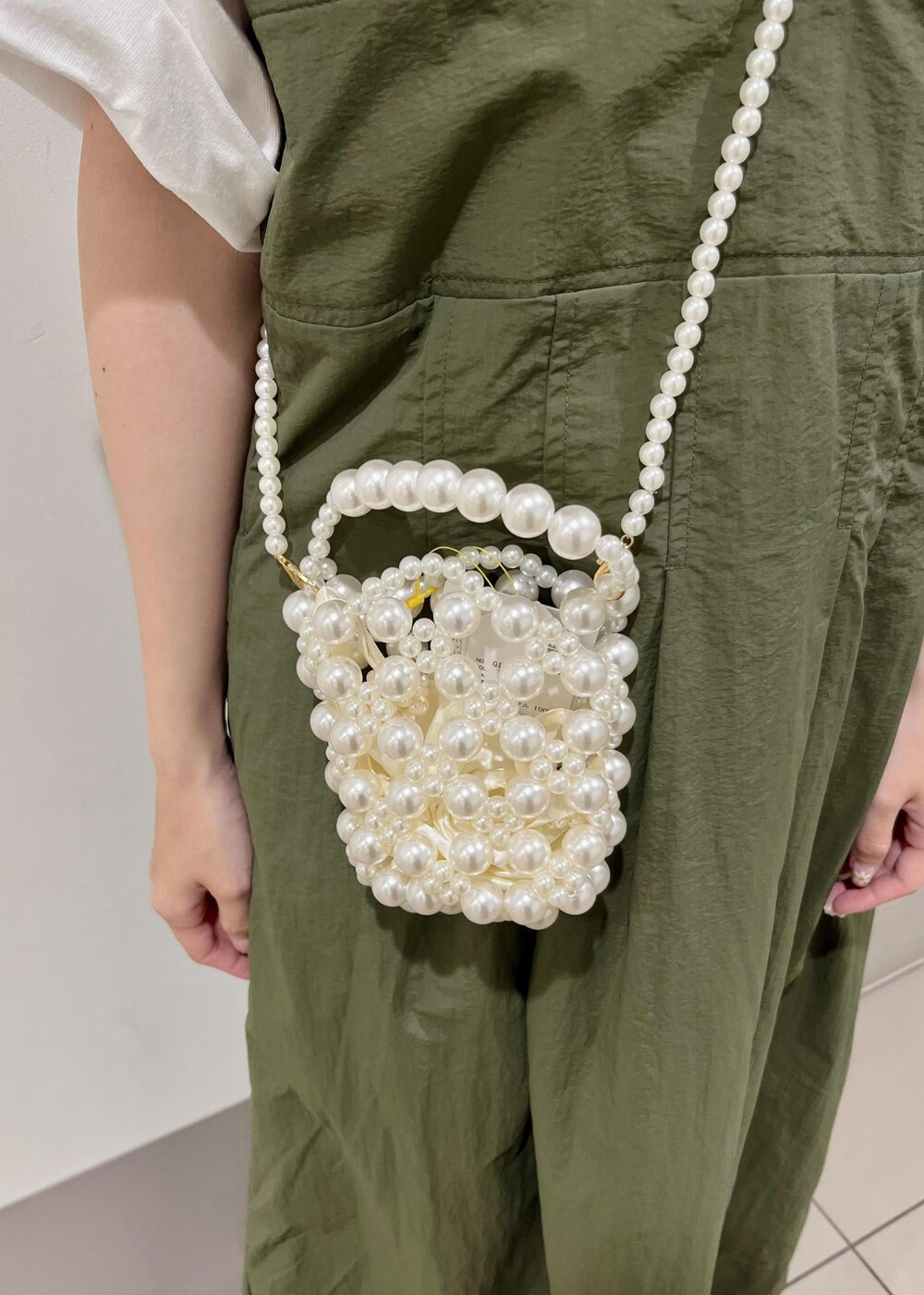 グリーン系のワンピース、ホワイト系のショルダーバッグ、ホワイト系のTシャツ/カットソーを着用したレディースの夏コーディネートの5枚目の写真