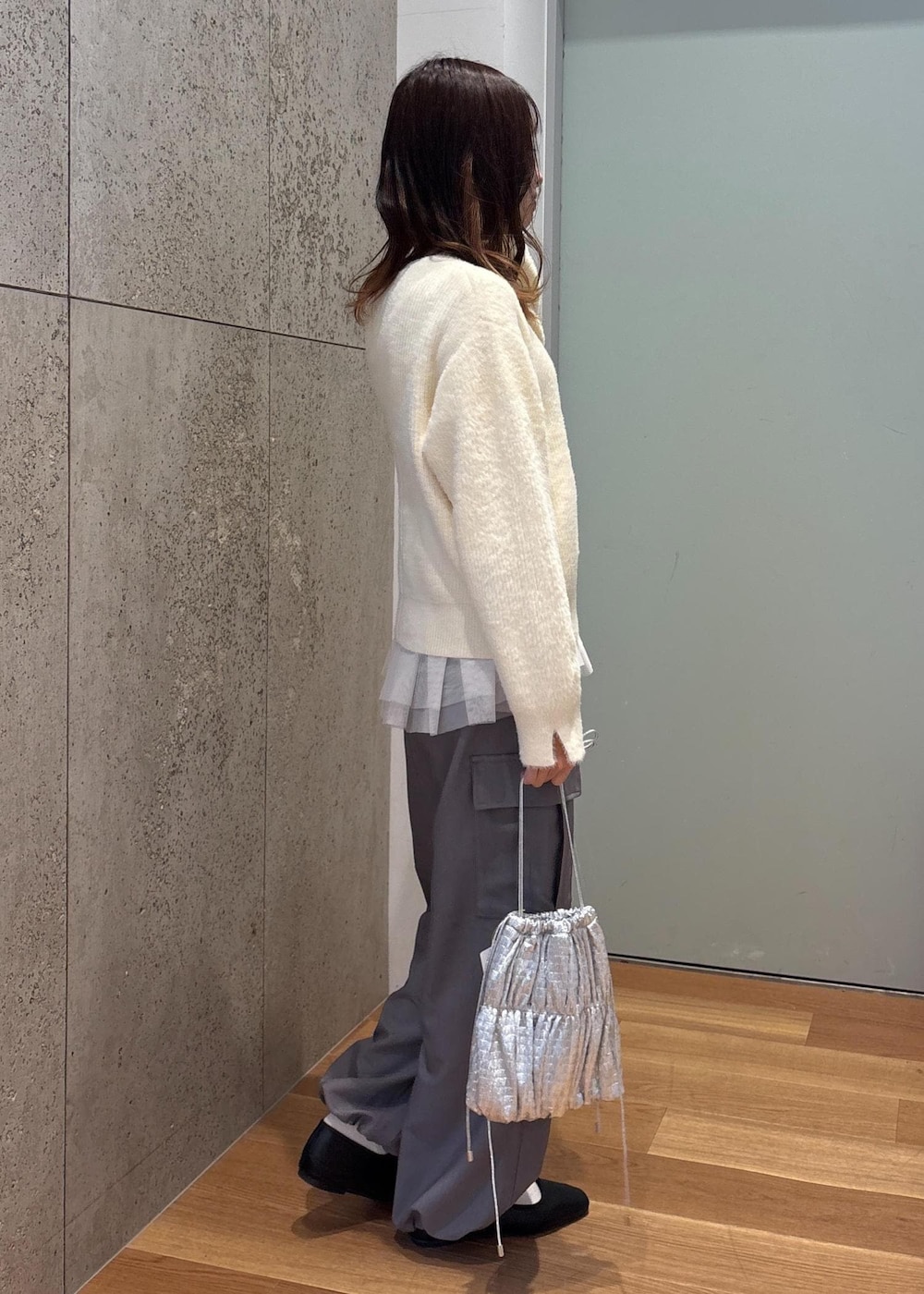 ホワイト系のベスト、シルバー系のショルダーバッグ、ホワイト系のニット/セーターを着用したレディースの春コーディネートの4枚目の写真