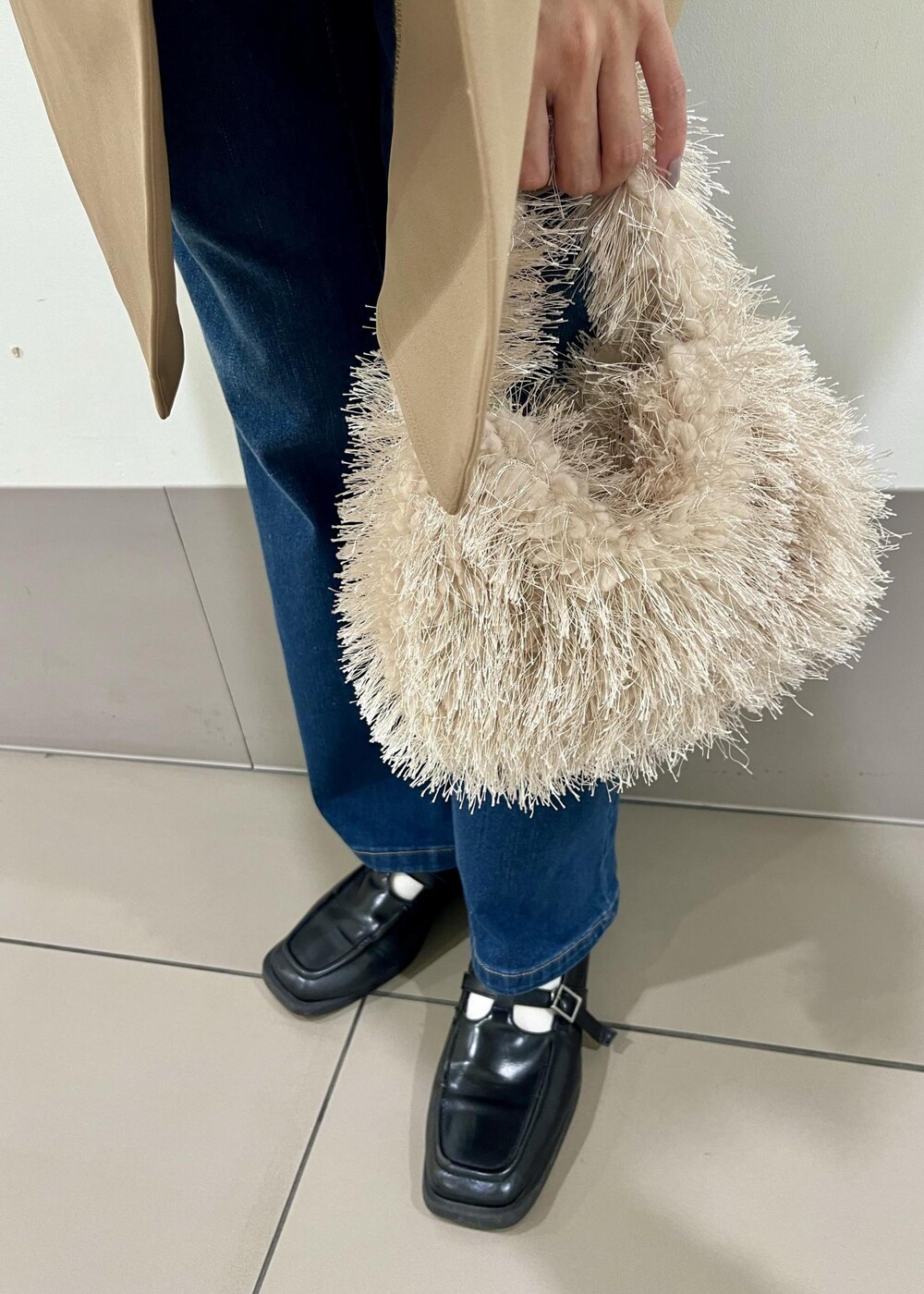 ブルー系のデニムパンツ、ベージュ系のハンドバッグ、ブルー系のTシャツ/カットソーを着用したレディースの秋コーディネートの5枚目の写真