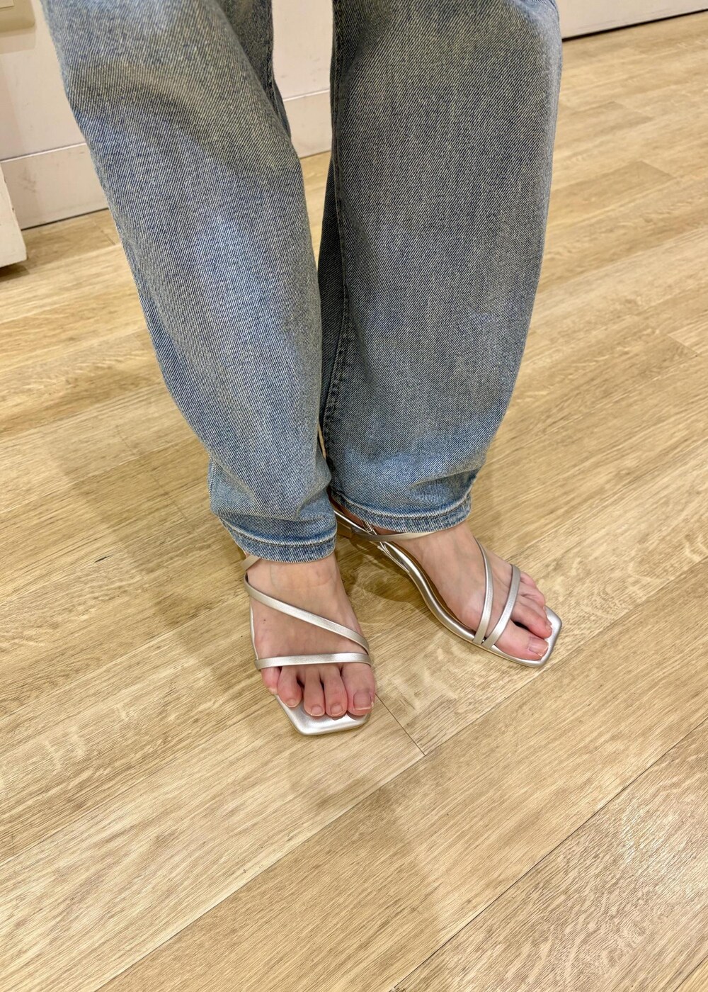 ブルー系のデニムパンツ、ブラック系のショルダーバッグ、シルバー系のサンダルを着用したレディースの夏コーディネートの7枚目の写真