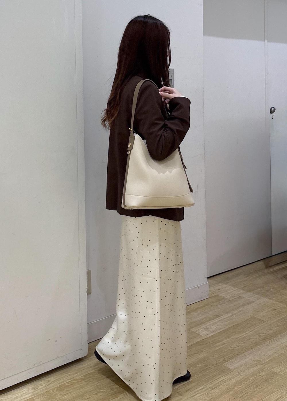 ホワイト系のショルダーバッグ、ベージュ系のTシャツ/カットソー、ブラウン系のテーラードジャケットを着用したレディースの春コーディネートの3枚目の写真