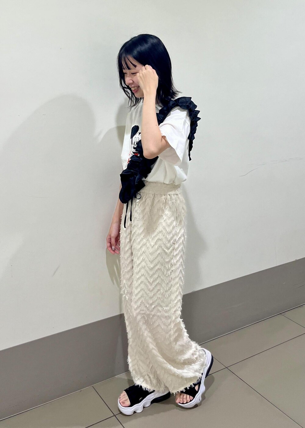 ブラック系のショルダーバッグ、ホワイト系のTシャツ/カットソー、ベージュ系のその他パンツを着用したレディースの夏コーディネートの2枚目の写真