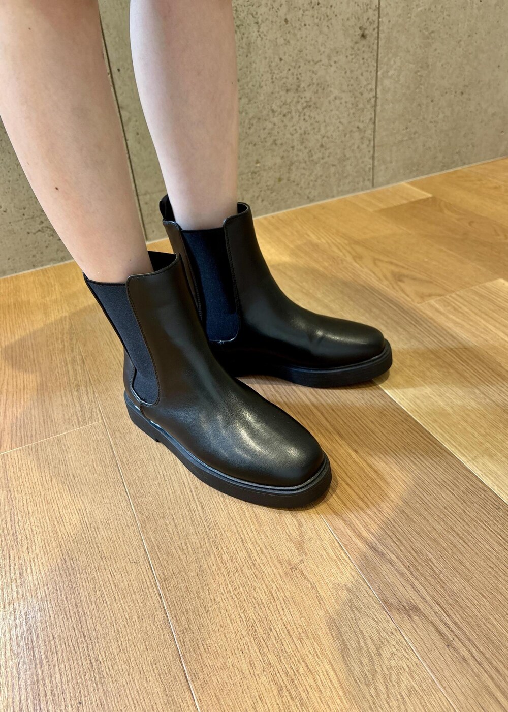 グリーン系のショルダーバッグ、ブラック系のブーツ、グレー系のスカートを着用したレディースの冬コーディネートの4枚目の写真