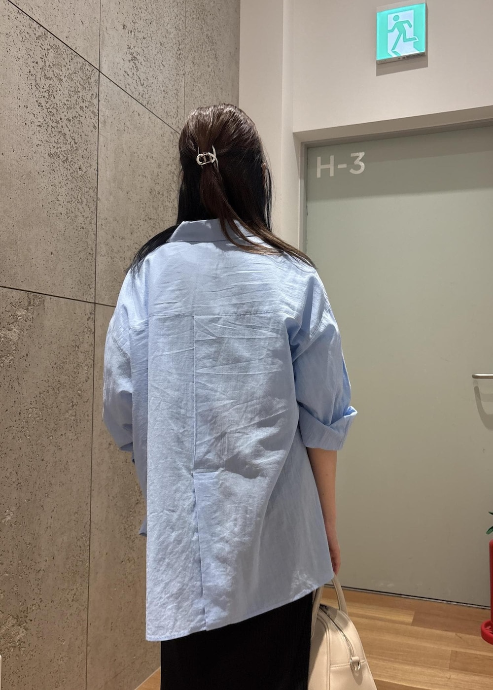 ブラック系のスカート、ブルー系のシャツ/ブラウス、ホワイト系のTシャツ/カットソーを着用したレディースの春コーディネートの6枚目の写真