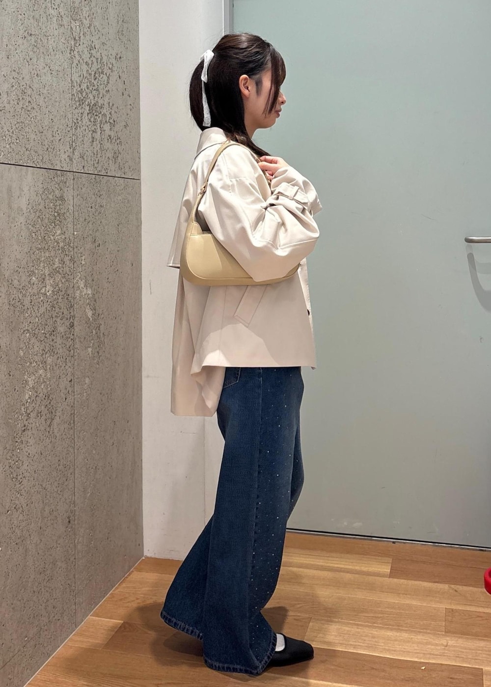 ベージュ系のハンドバッグ、ブルー系のデニムパンツ、ブルー系のシャツ/ブラウスを着用したレディースの春コーディネートの3枚目の写真