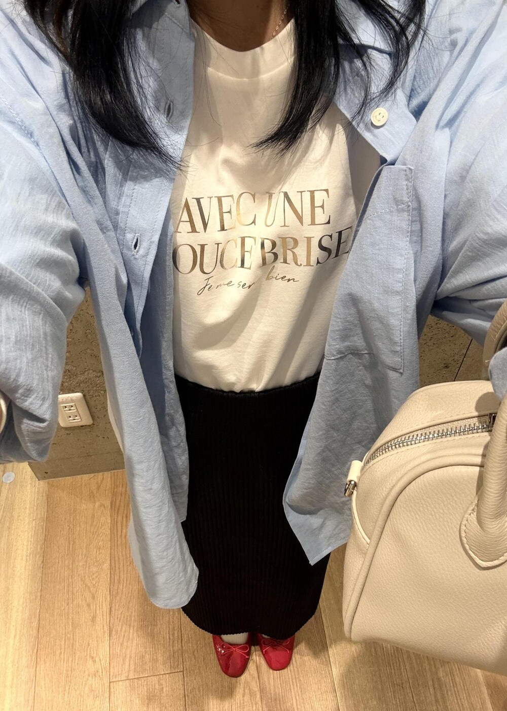 ブラック系のスカート、ブルー系のシャツ/ブラウス、ホワイト系のTシャツ/カットソーを着用したレディースの春コーディネートの7枚目の写真