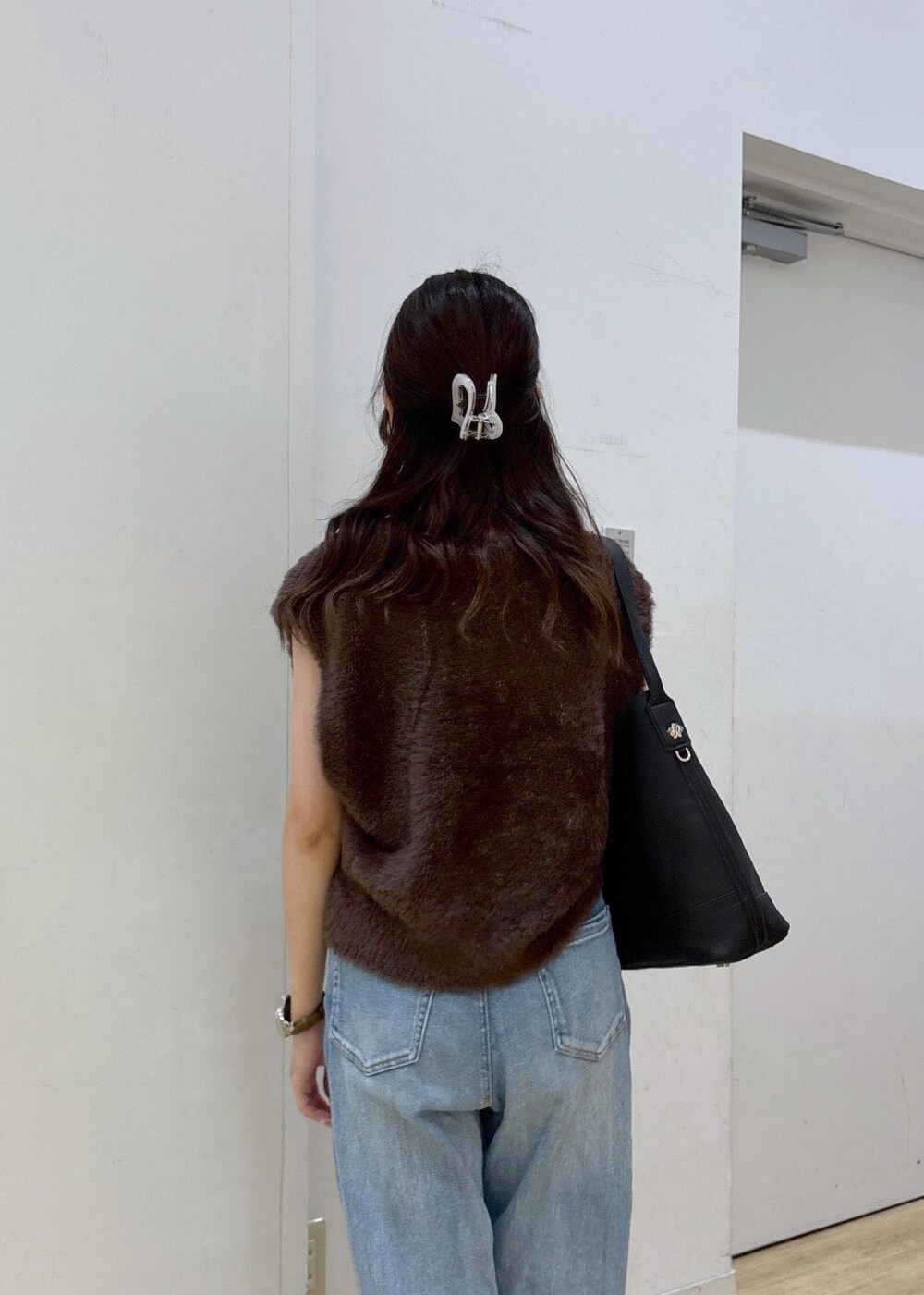 ブルー系のデニムパンツ、ブラック系のサンダル、ブラック系のショルダーバッグを着用したレディースの夏コーディネートの3枚目の写真