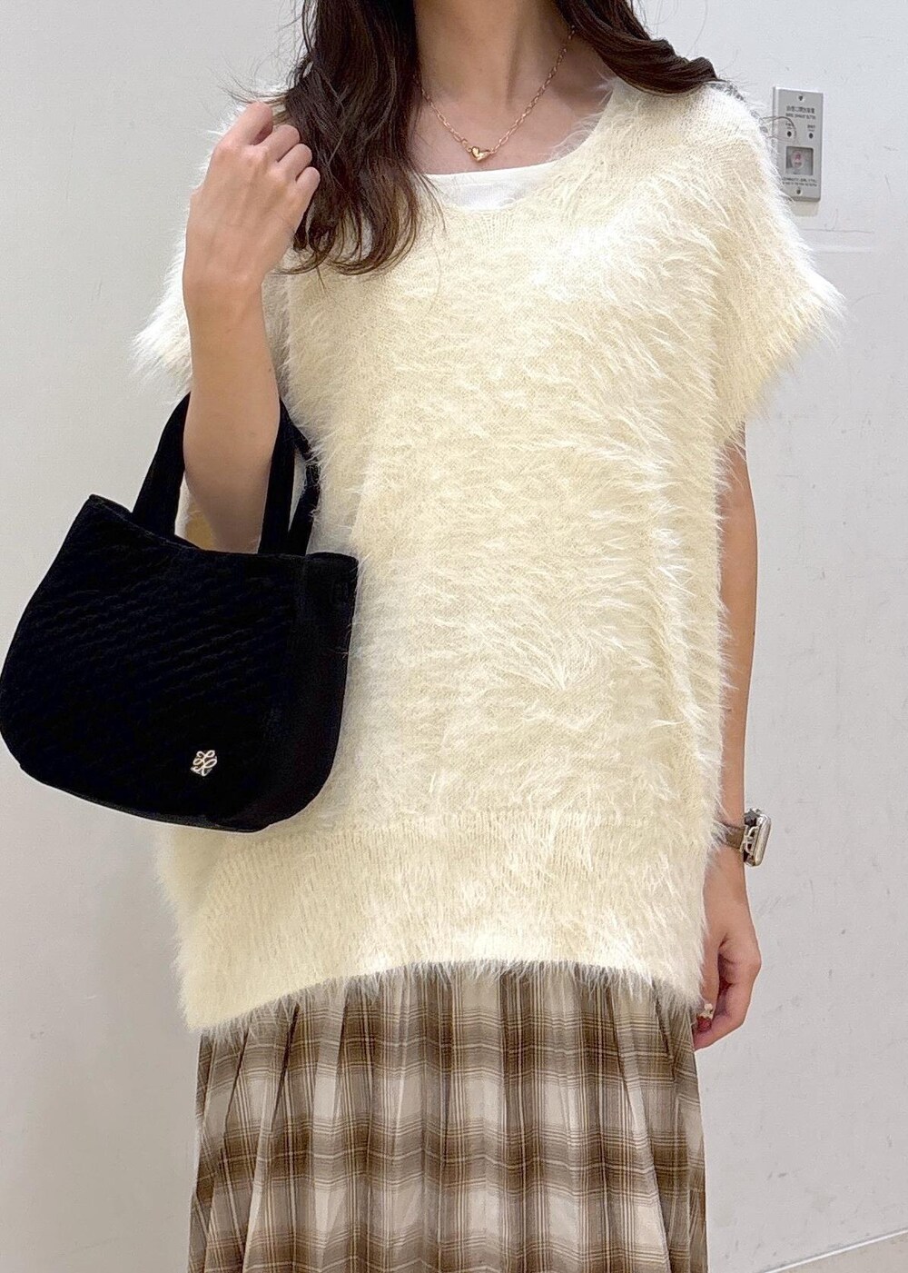 ホワイト系のタンクトップ、ホワイト系のベスト、イエロー系のスカートを着用したレディースの秋コーディネートの6枚目の写真