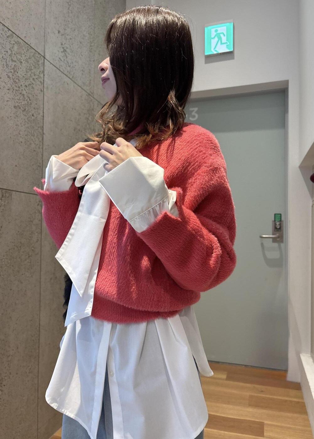 ブルー系のデニムパンツ、ホワイト系のシャツ/ブラウス、ピンク系のニット/セーターを着用したレディースの冬コーディネートの6枚目の写真