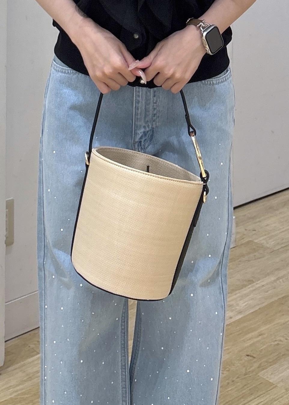 ブルー系のデニムパンツ、ブラック系のサンダル、ブラック系のハンドバッグを着用したレディースの春コーディネートの7枚目の写真