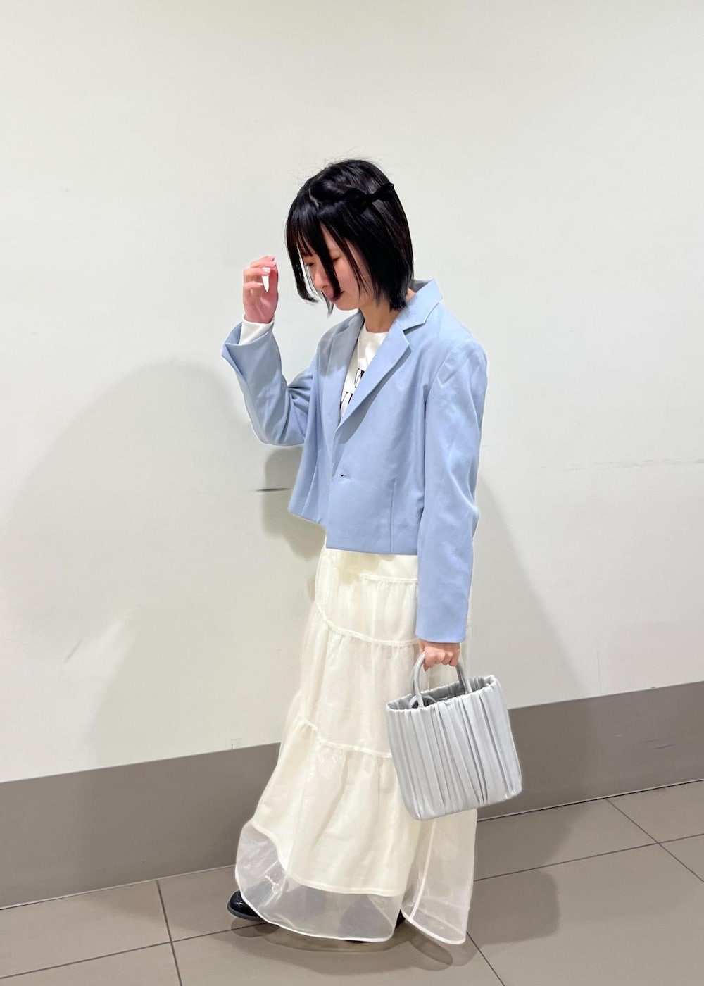 ブラック系のローファー、シルバー系のハンドバッグ、ホワイト系のTシャツ/カットソーを着用したレディースの春コーディネートの2枚目の写真