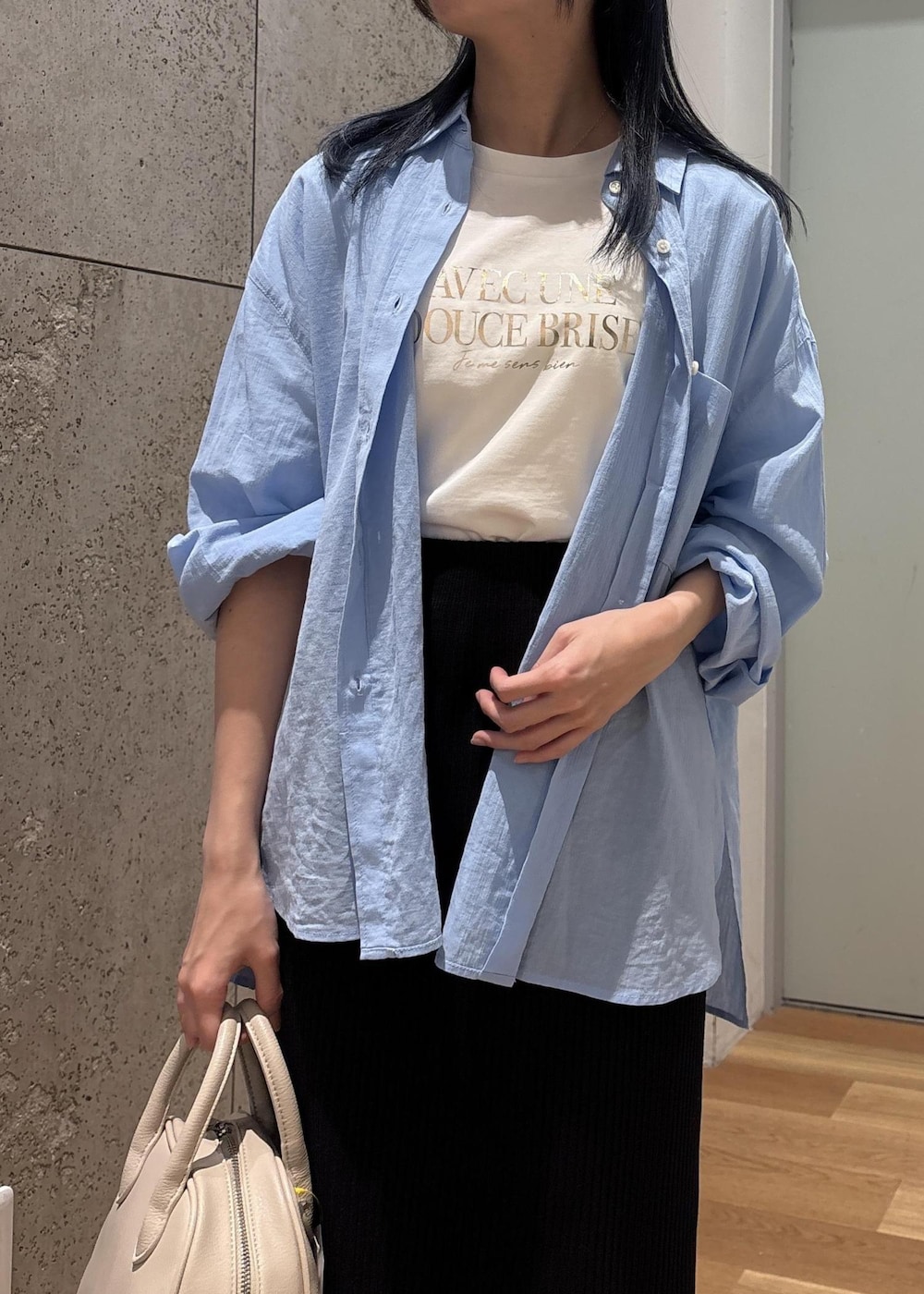 ブラック系のスカート、ブルー系のシャツ/ブラウス、ホワイト系のTシャツ/カットソーを着用したレディースの春コーディネートの5枚目の写真