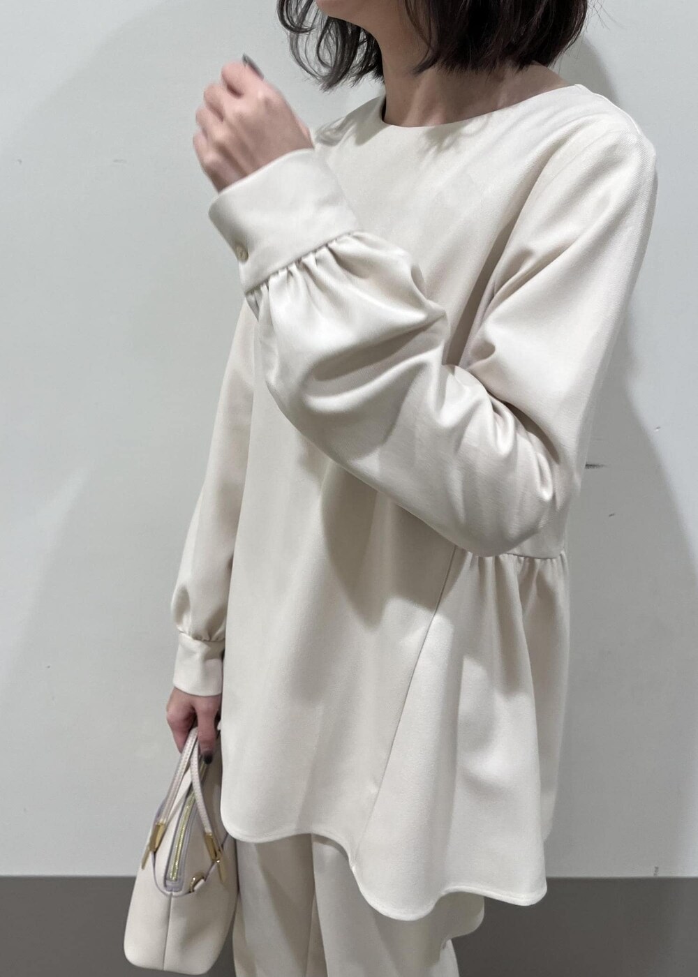 ホワイト系のショルダーバッグ、ホワイト系のパンプス、ホワイト系のシャツ/ブラウスを着用したレディースの冬コーディネートの4枚目の写真