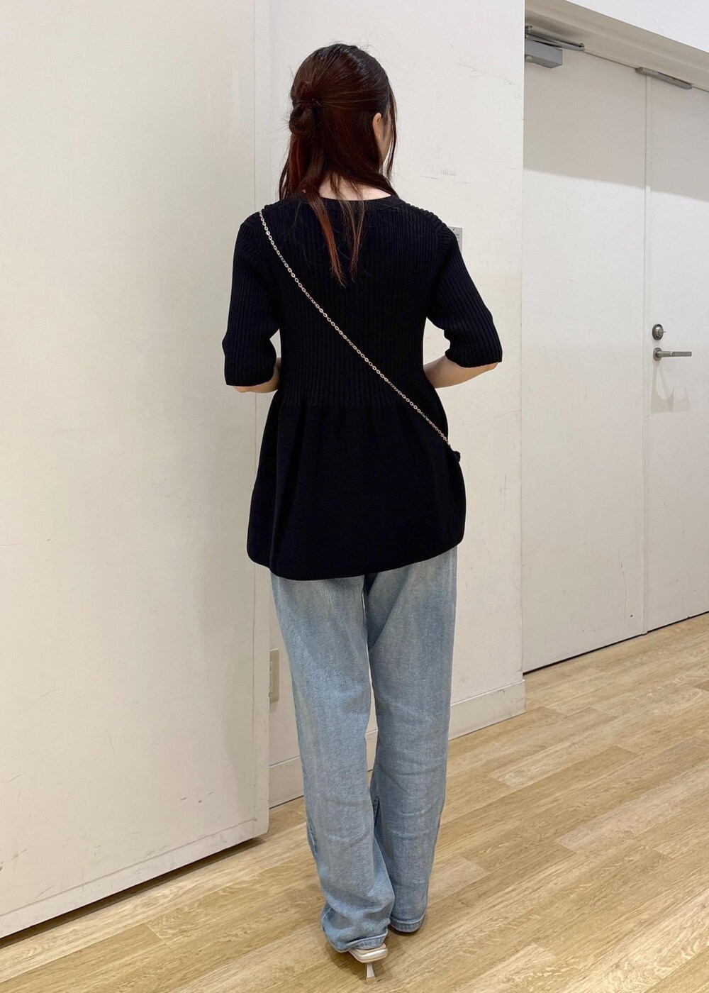 ブルー系のデニムパンツ、ブラック系のショルダーバッグ、シルバー系のサンダルを着用したレディースの夏コーディネートの3枚目の写真