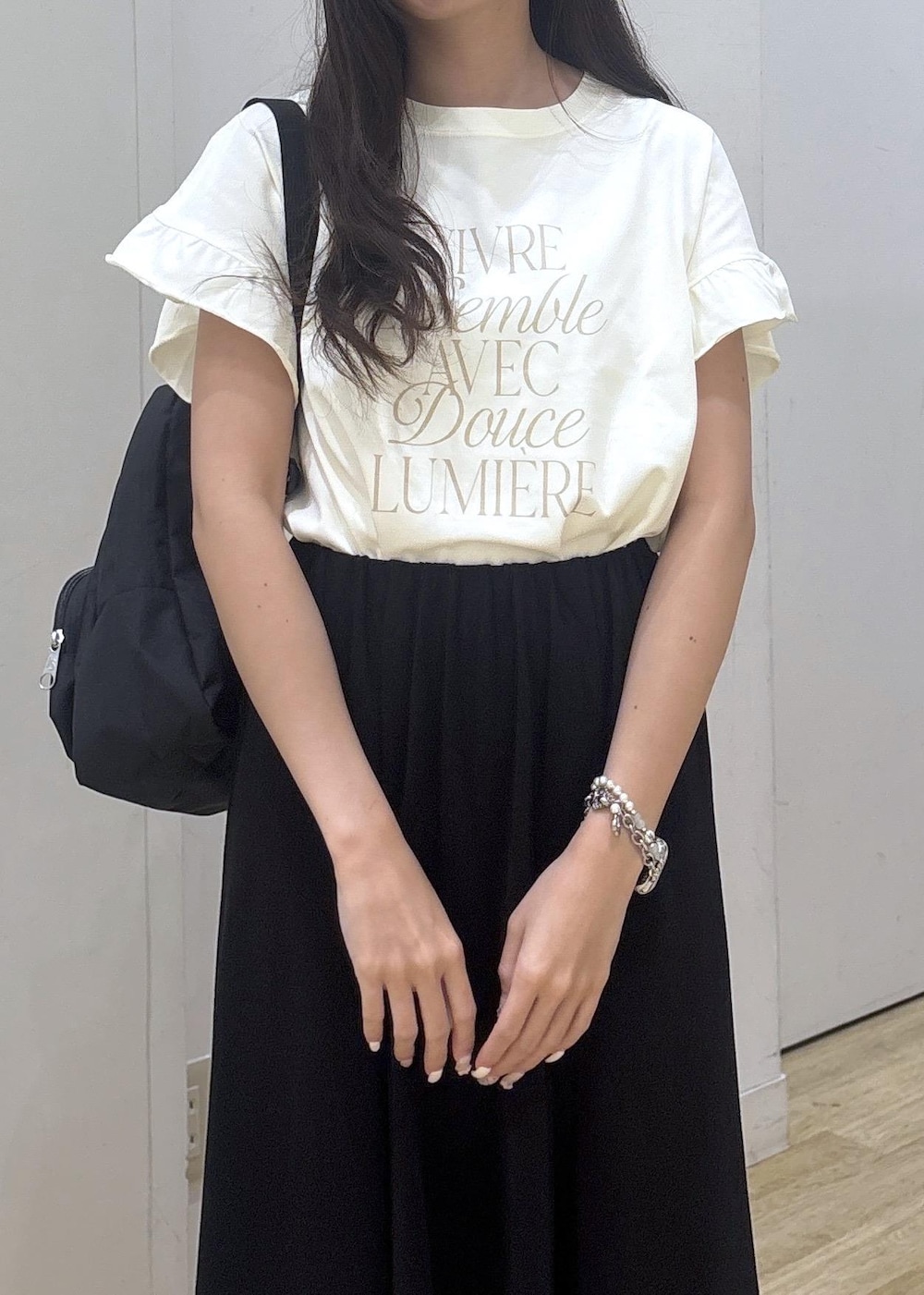 ブラック系のサンダル、ホワイト系のTシャツ/カットソー、ブラック系のスカートを着用したレディースの夏コーディネートの6枚目の写真