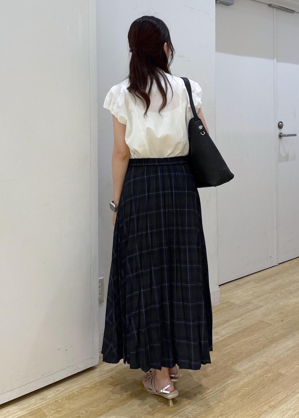 シルバー系のサンダル、ブラック系のショルダーバッグ、グリーン系のスカートを着用したレディースの夏コーディネートの3枚目の写真