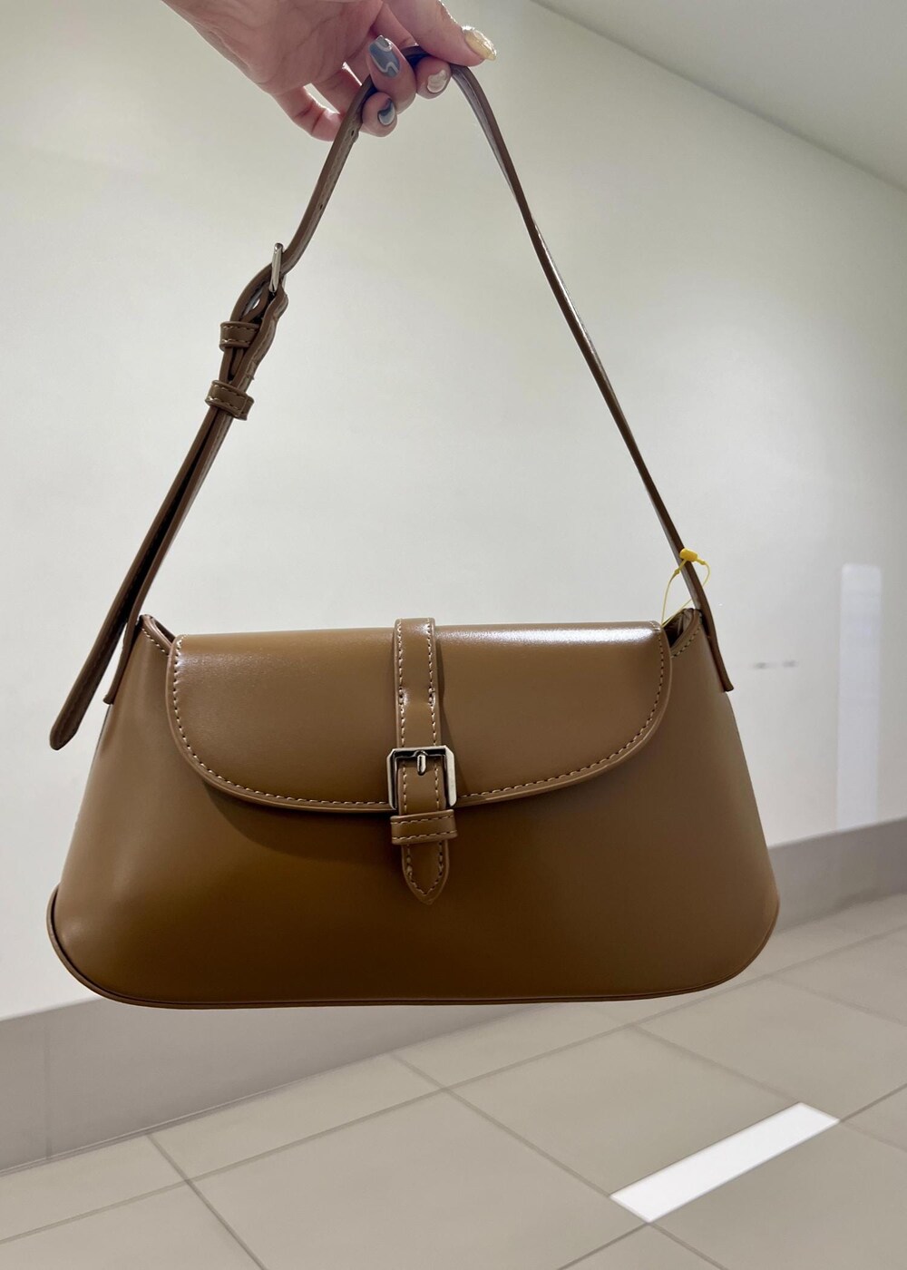 ブラック系のニット/セーター、ブラウン系のテーラードジャケット、ブラウン系のショルダーバッグを着用したレディースの秋コーディネートの6枚目の写真