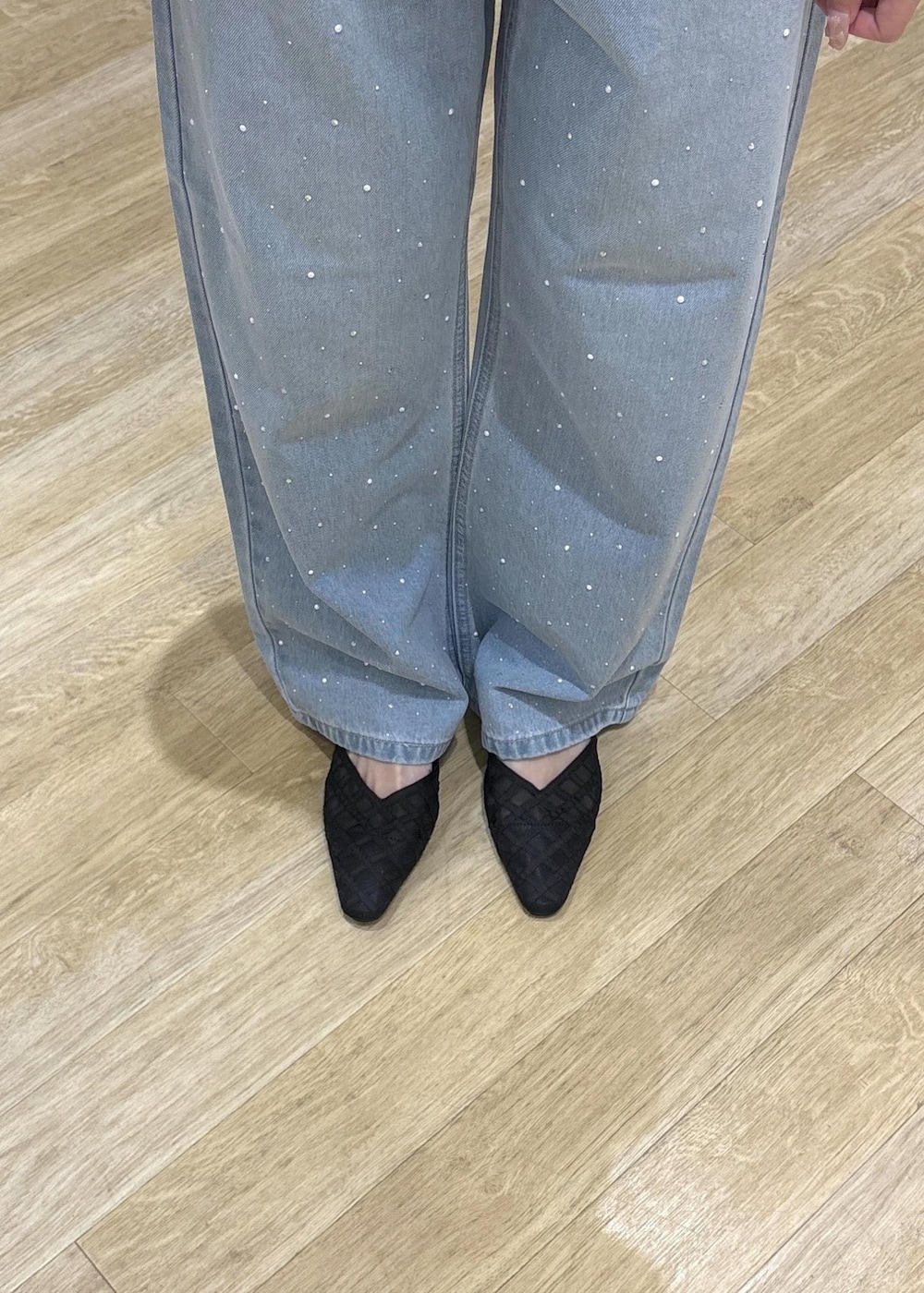 ブルー系のデニムパンツ、ブラック系のサンダル、ブラック系のハンドバッグを着用したレディースの春コーディネートの8枚目の写真