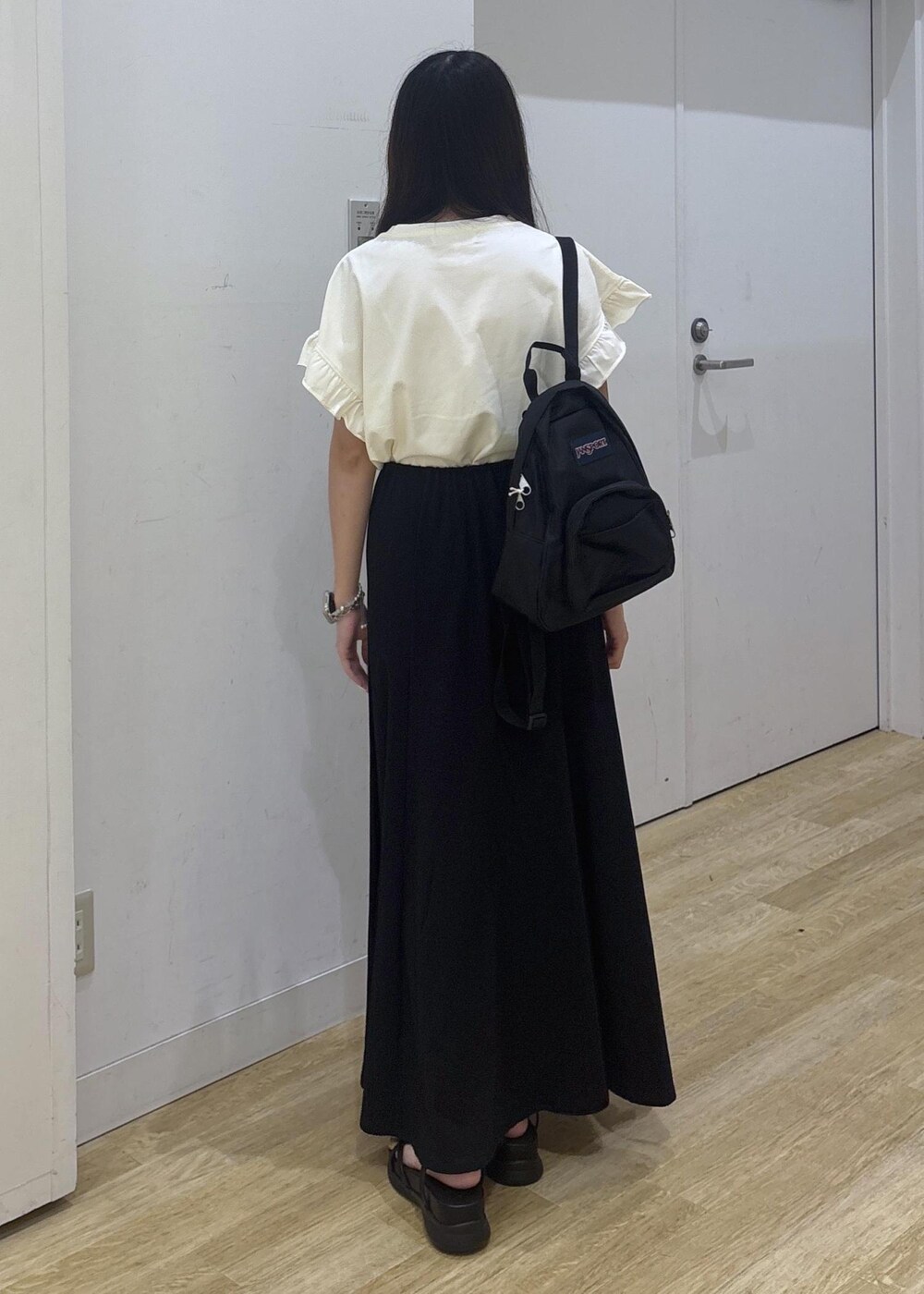 ブラック系のサンダル、ホワイト系のTシャツ/カットソー、ブラック系のスカートを着用したレディースの夏コーディネートの4枚目の写真