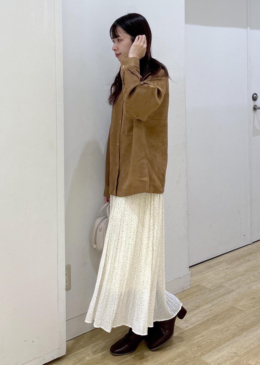 ホワイト系のスカート、ブラウン系のシャツ/ブラウス、ブラウン系のブーツを着用したレディースの秋コーディネートの3枚目の写真