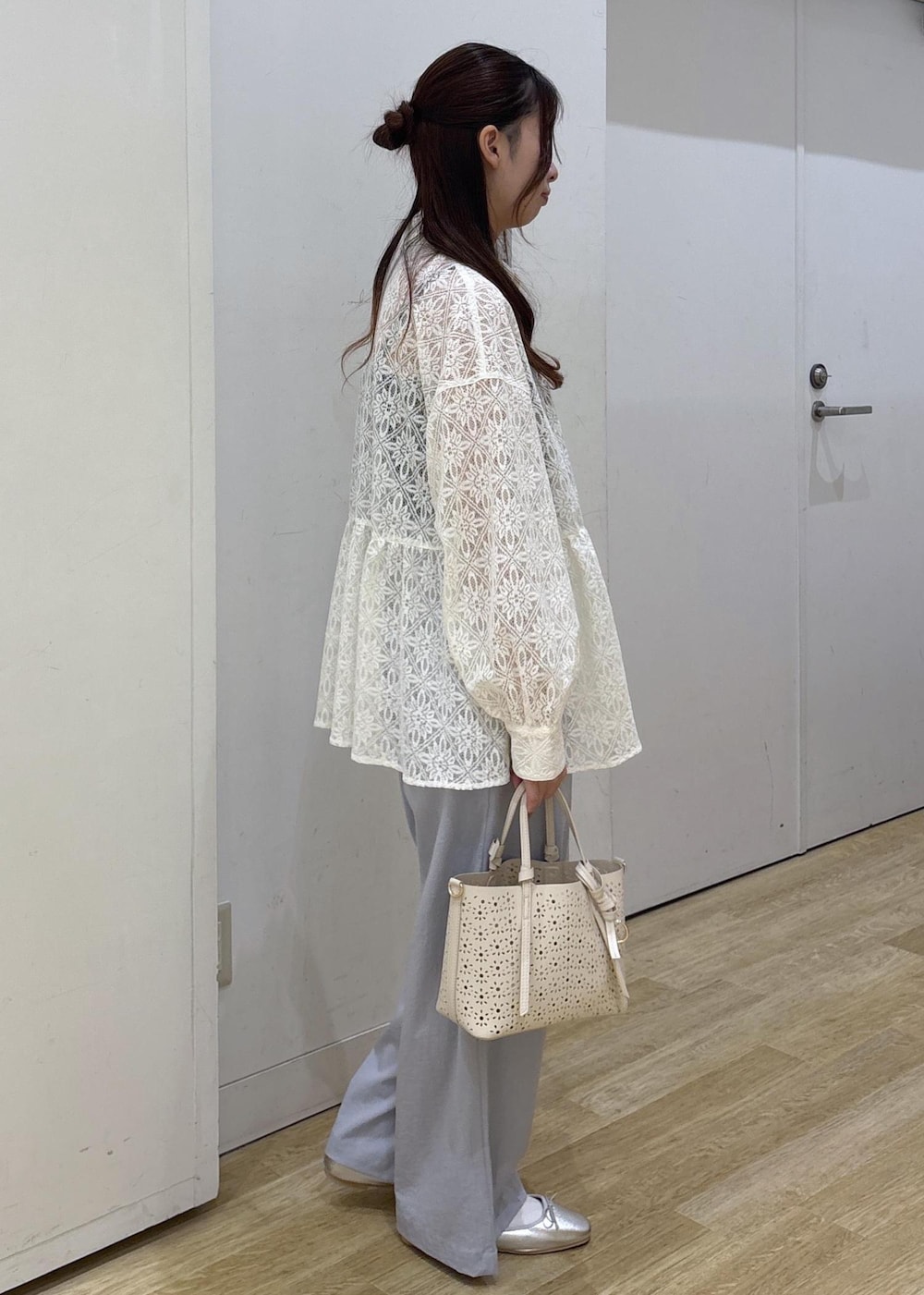 ホワイト系のショルダーバッグ、ホワイト系のシャツ/ブラウス、シルバー系のバレエシューズを着用したレディースの春コーディネートの3枚目の写真