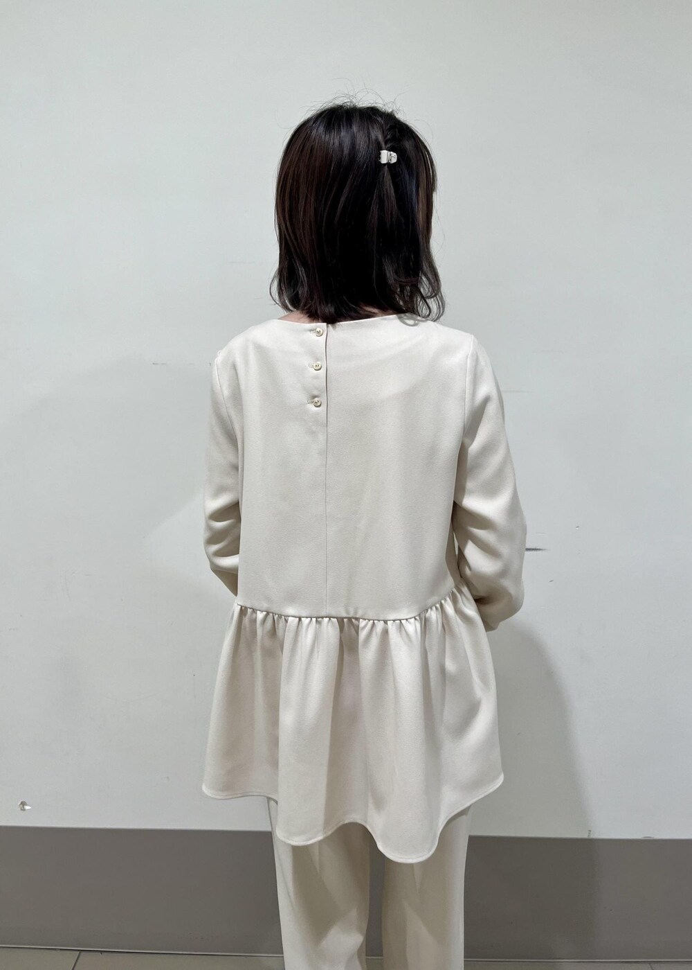 ホワイト系のショルダーバッグ、ホワイト系のパンプス、ホワイト系のシャツ/ブラウスを着用したレディースの冬コーディネートの3枚目の写真