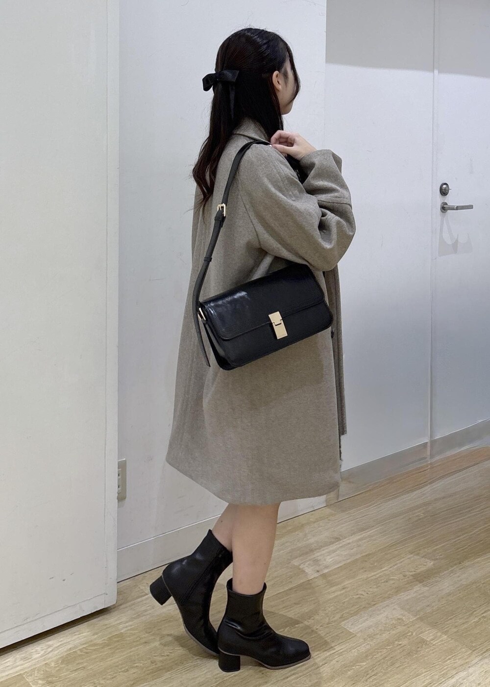 ブラック系のショルダーバッグ、レッド系のニット/セーター、ブラック系のブーツを着用したレディースの秋コーディネートの5枚目の写真