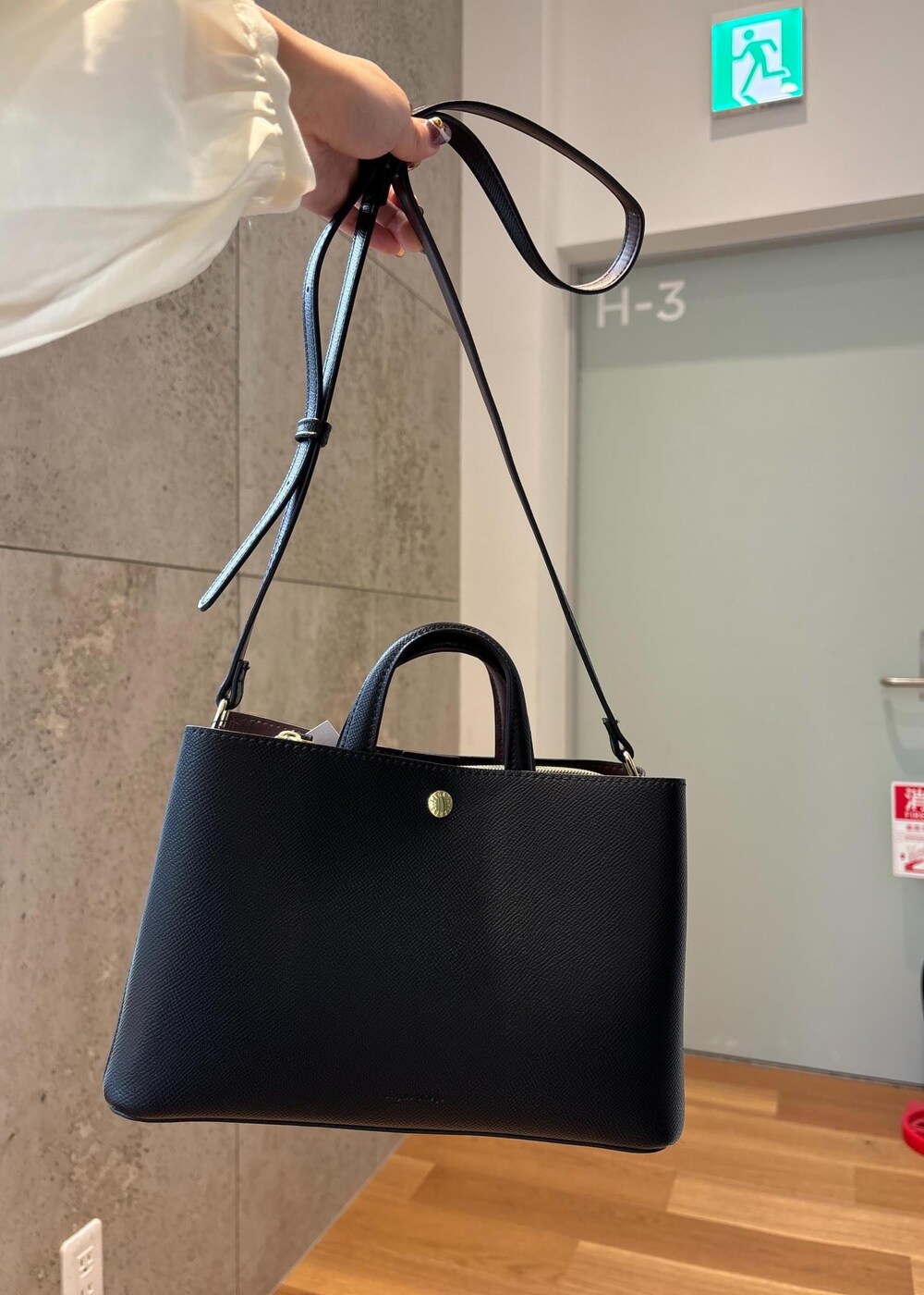 グレー系のスカート、ホワイト系のシャツ/ブラウス、ブラック系のブーツを着用したレディースの冬コーディネートの5枚目の写真