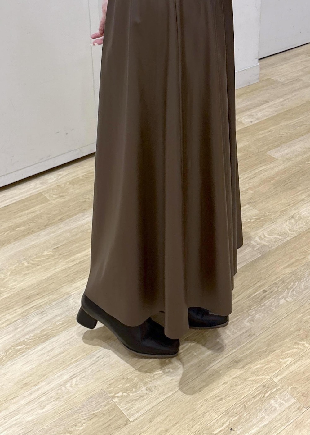 ブラウン系のスカート、イエロー系のポロシャツ、ブラック系のショルダーバッグを着用したレディースの秋コーディネートの8枚目の写真