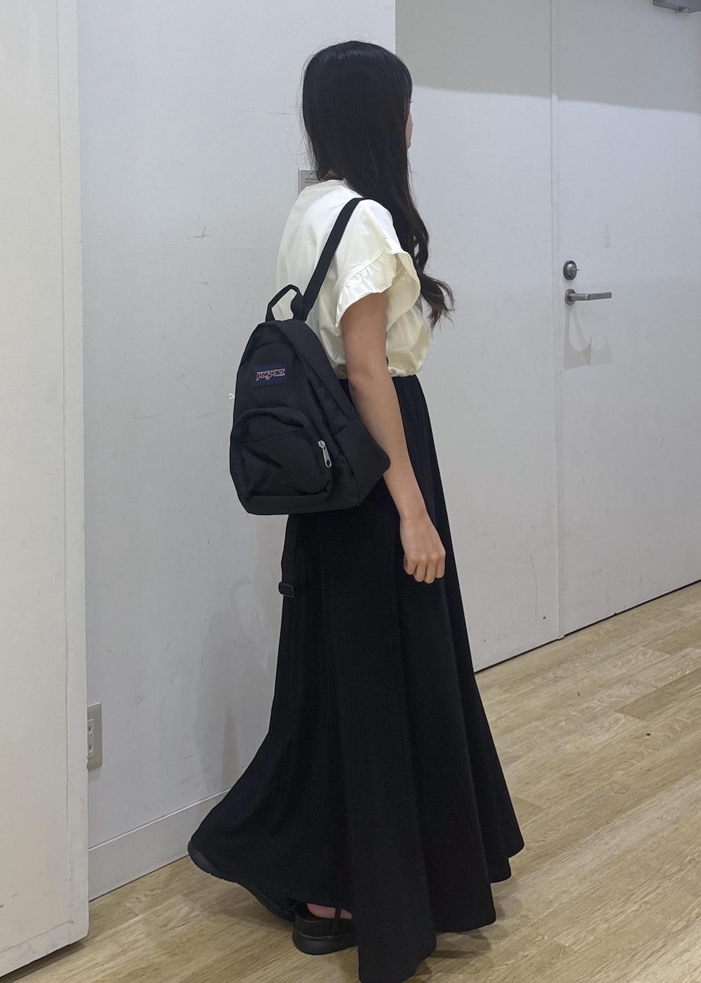 ブラック系のサンダル、ホワイト系のTシャツ/カットソー、ブラック系のスカートを着用したレディースの夏コーディネートの3枚目の写真