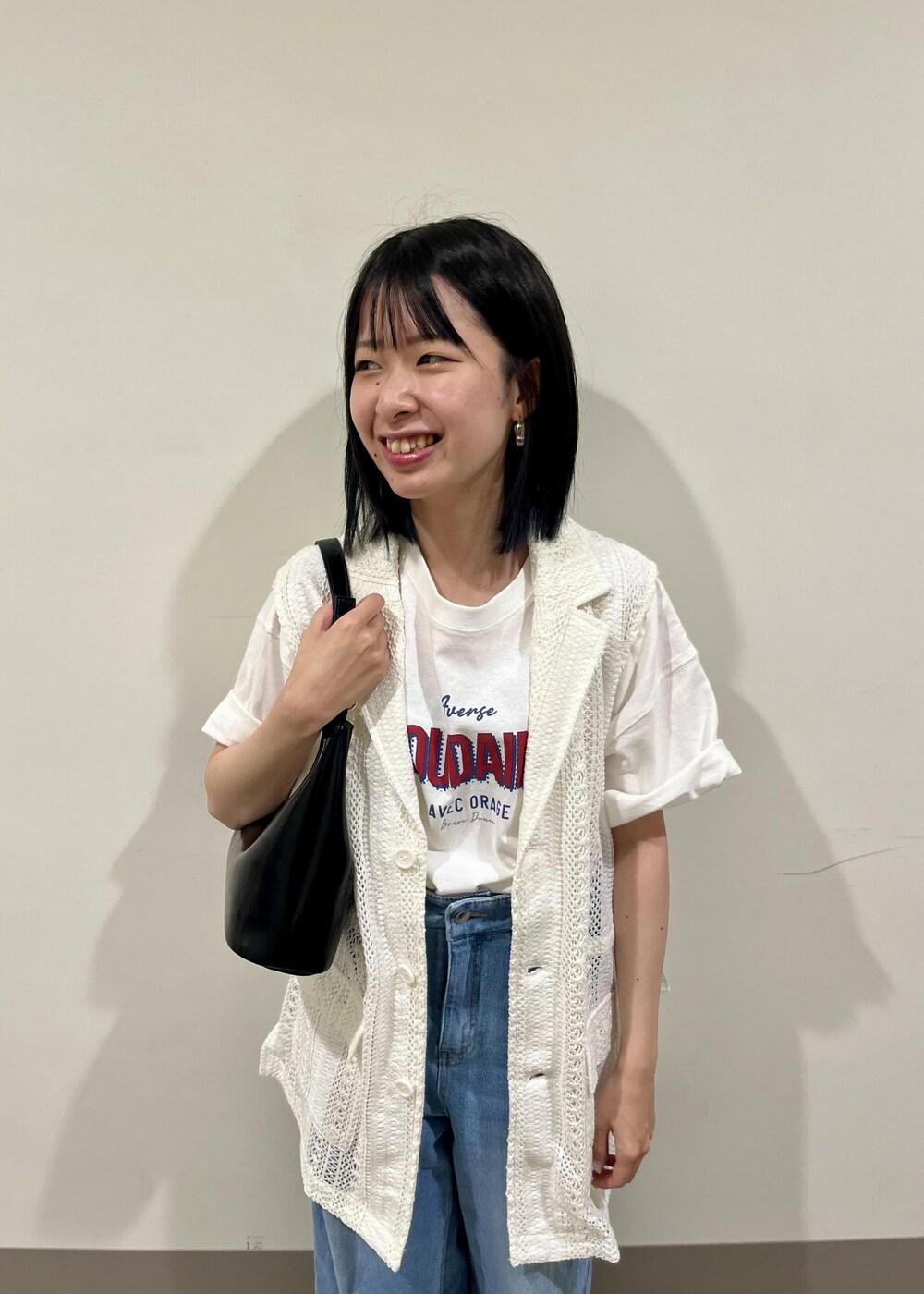 ブラック系のショルダーバッグ、ブルー系のデニムパンツ、ホワイト系のTシャツ/カットソーを着用したレディースの夏コーディネートの6枚目の写真